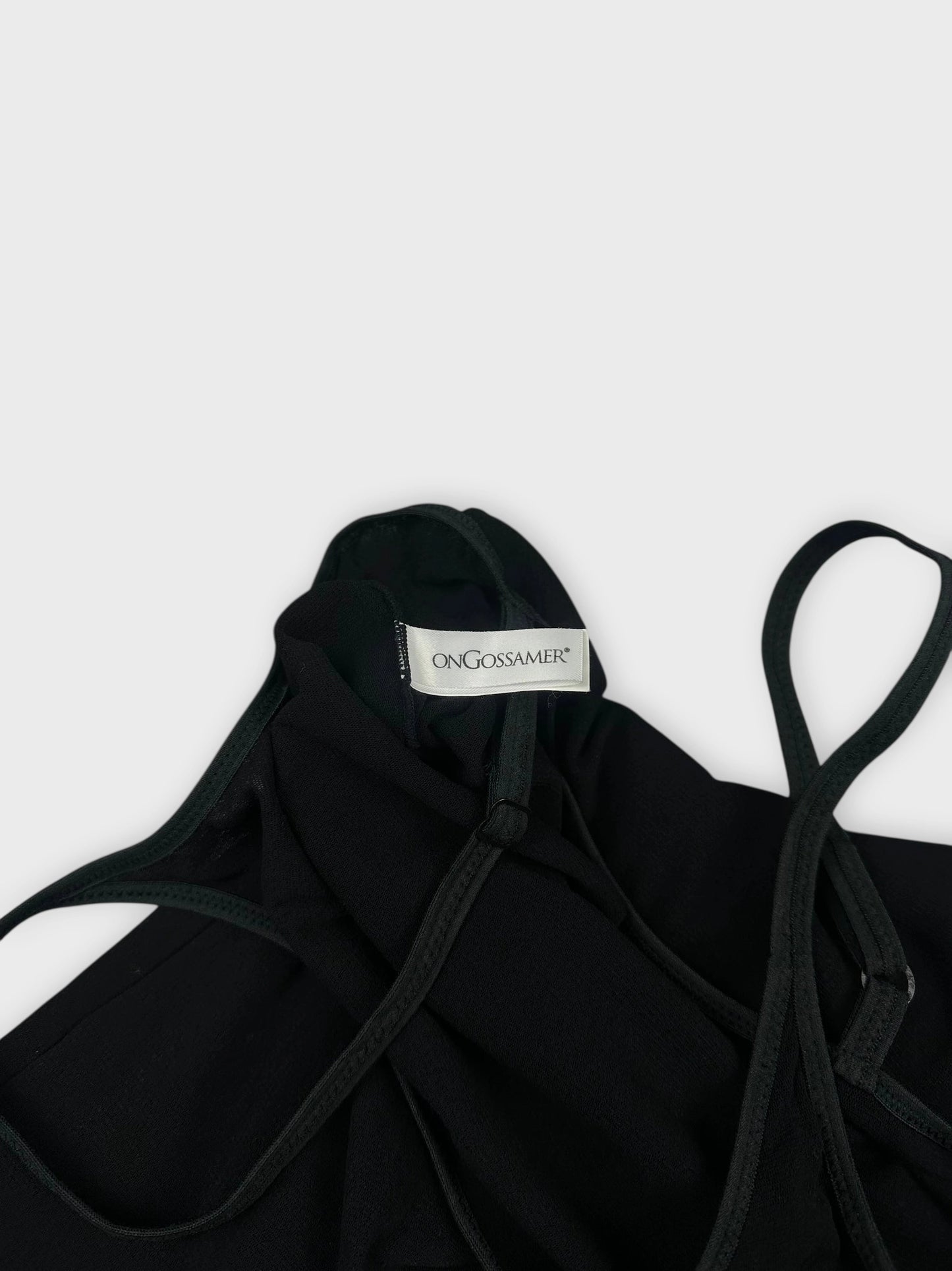 black top detail view featuring slim straps and a label