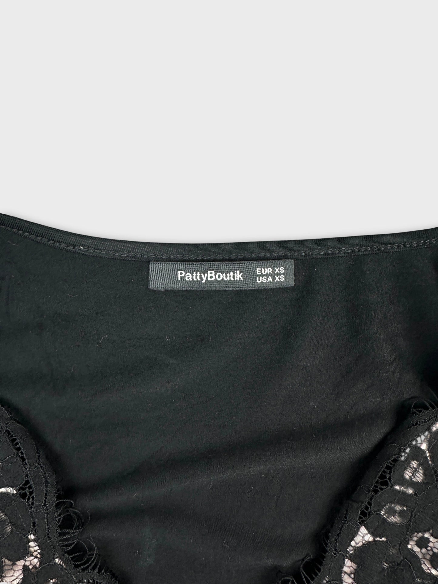 Detail view of a black women's top with lace trim.