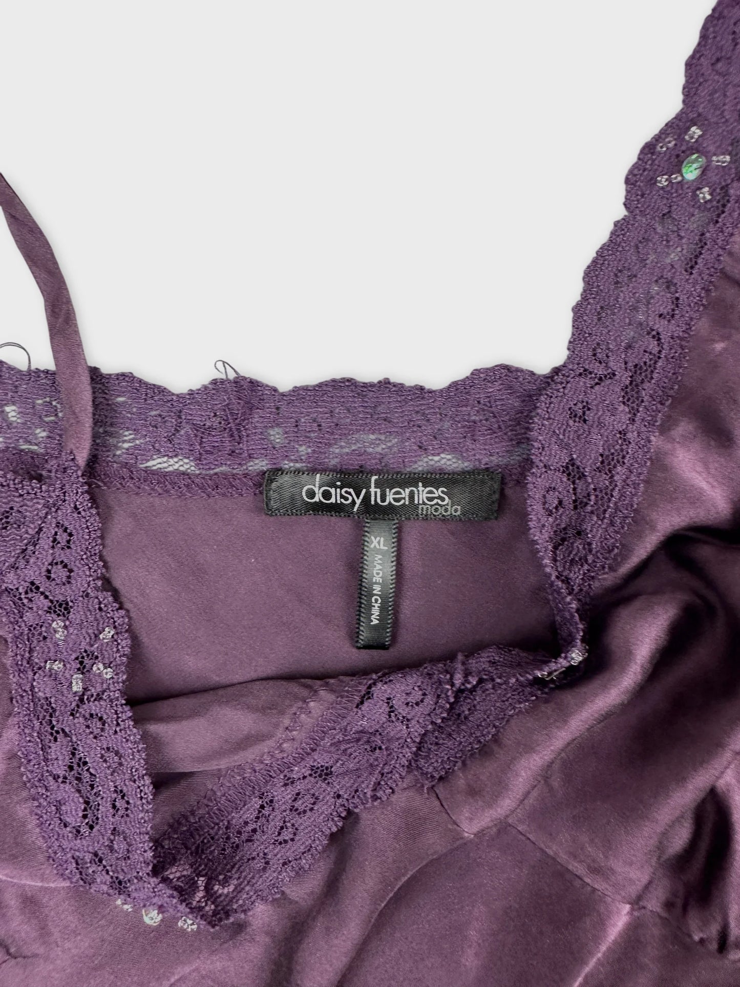 Detail view of a purple women’s top with lace trim.