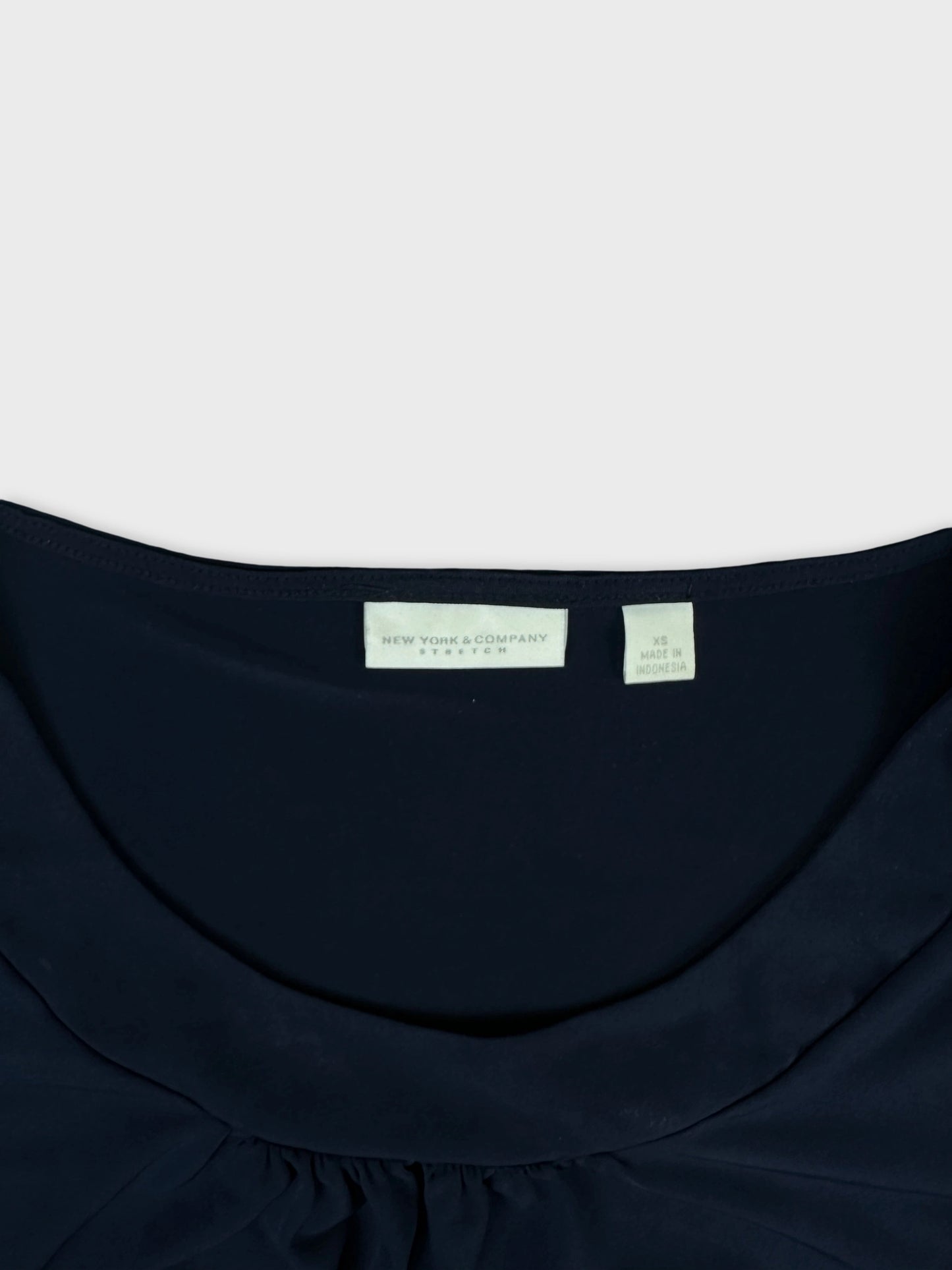 Detail view of a dark navy blue women's top with a rounded neckline.