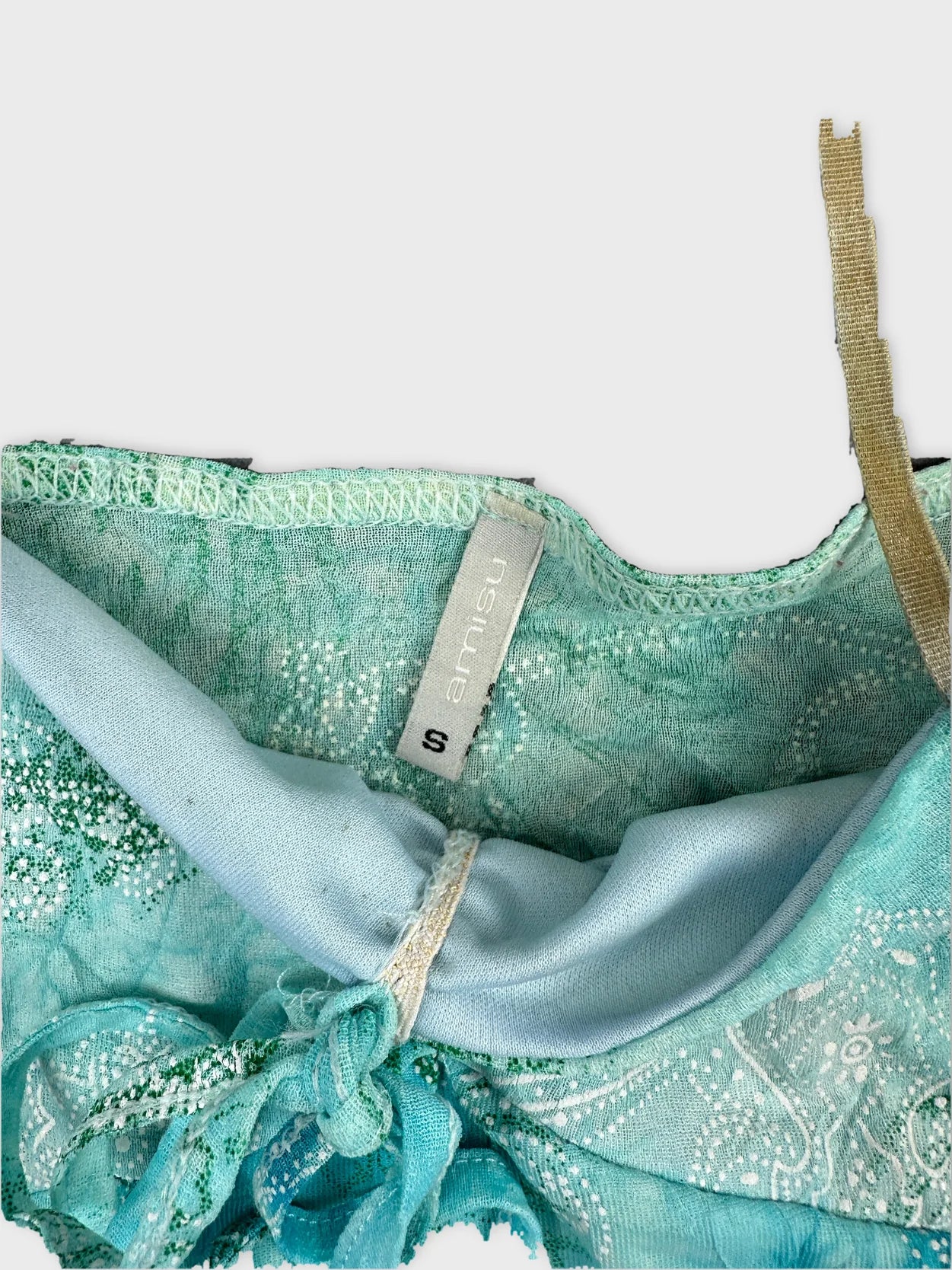 Detail view of a turquoise vintage upper body top with lace trim.