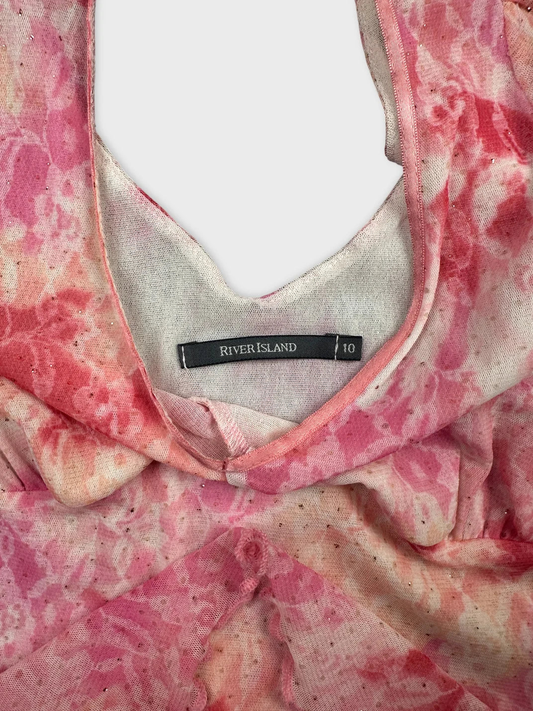 Detail view of a pink floral vintage top with a scoop neckline.