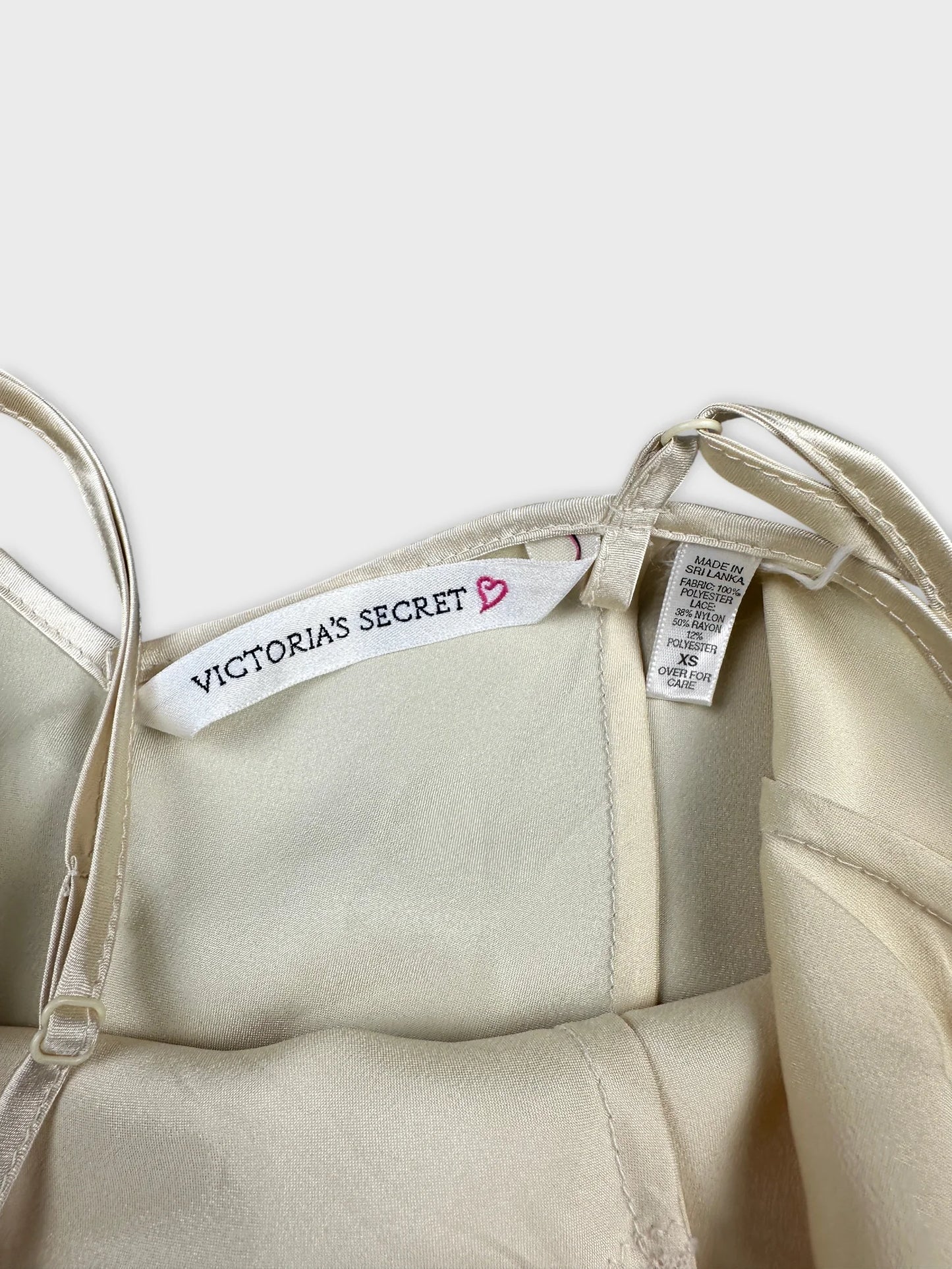 Detail view of a vintage cream top with satin trim.