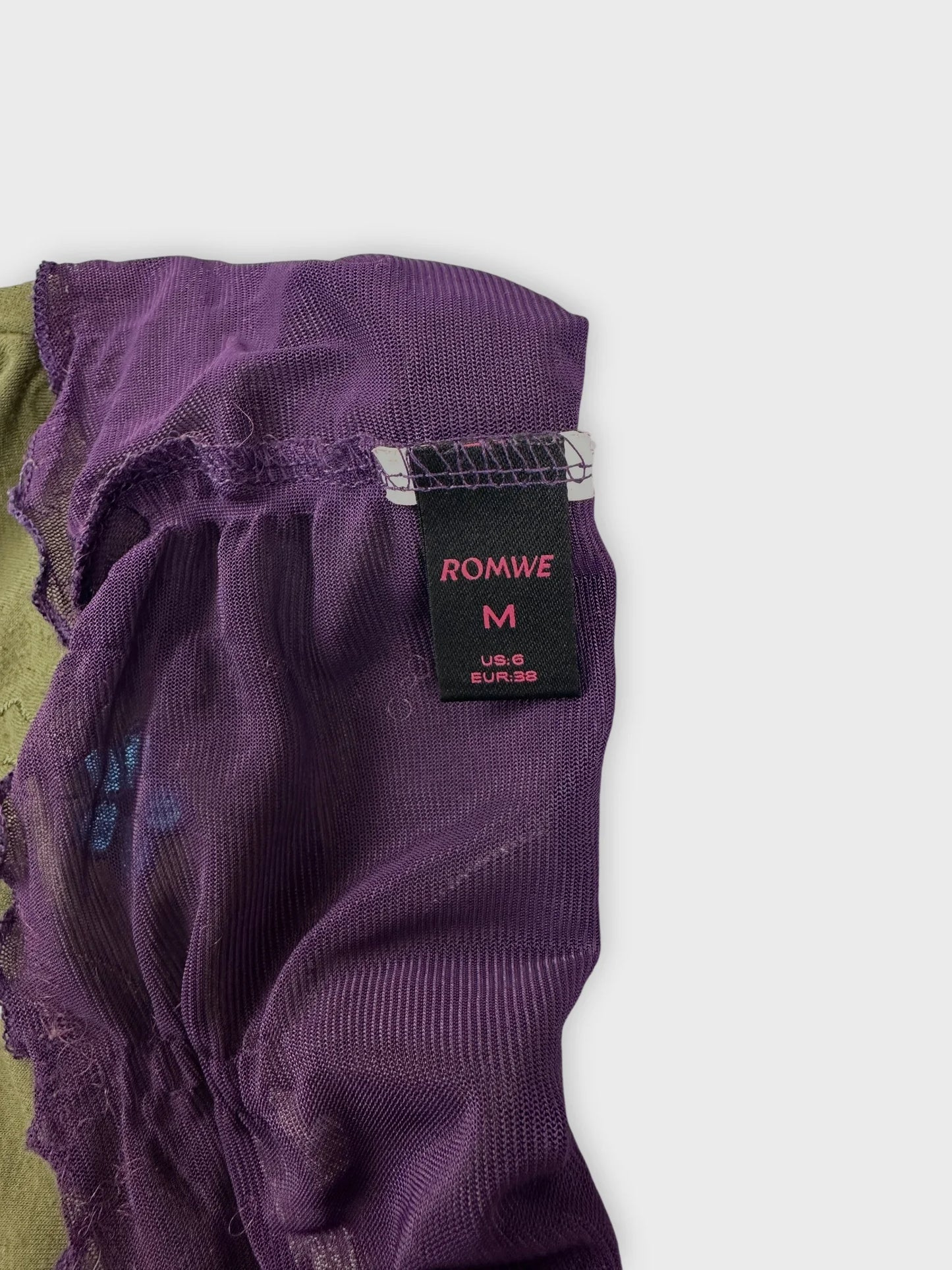 Detail view of a purple vintage top featuring a textured fabric.
