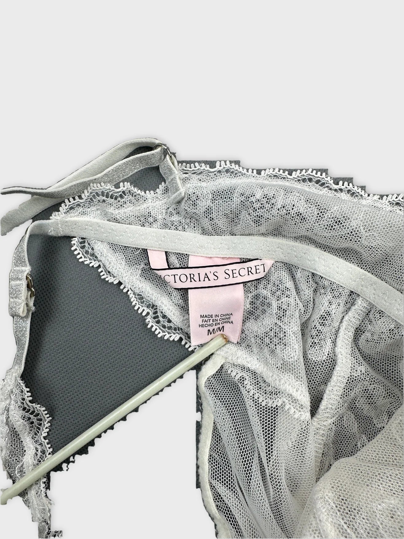 Detail view of a light gray vintage lace top with spaghetti straps.