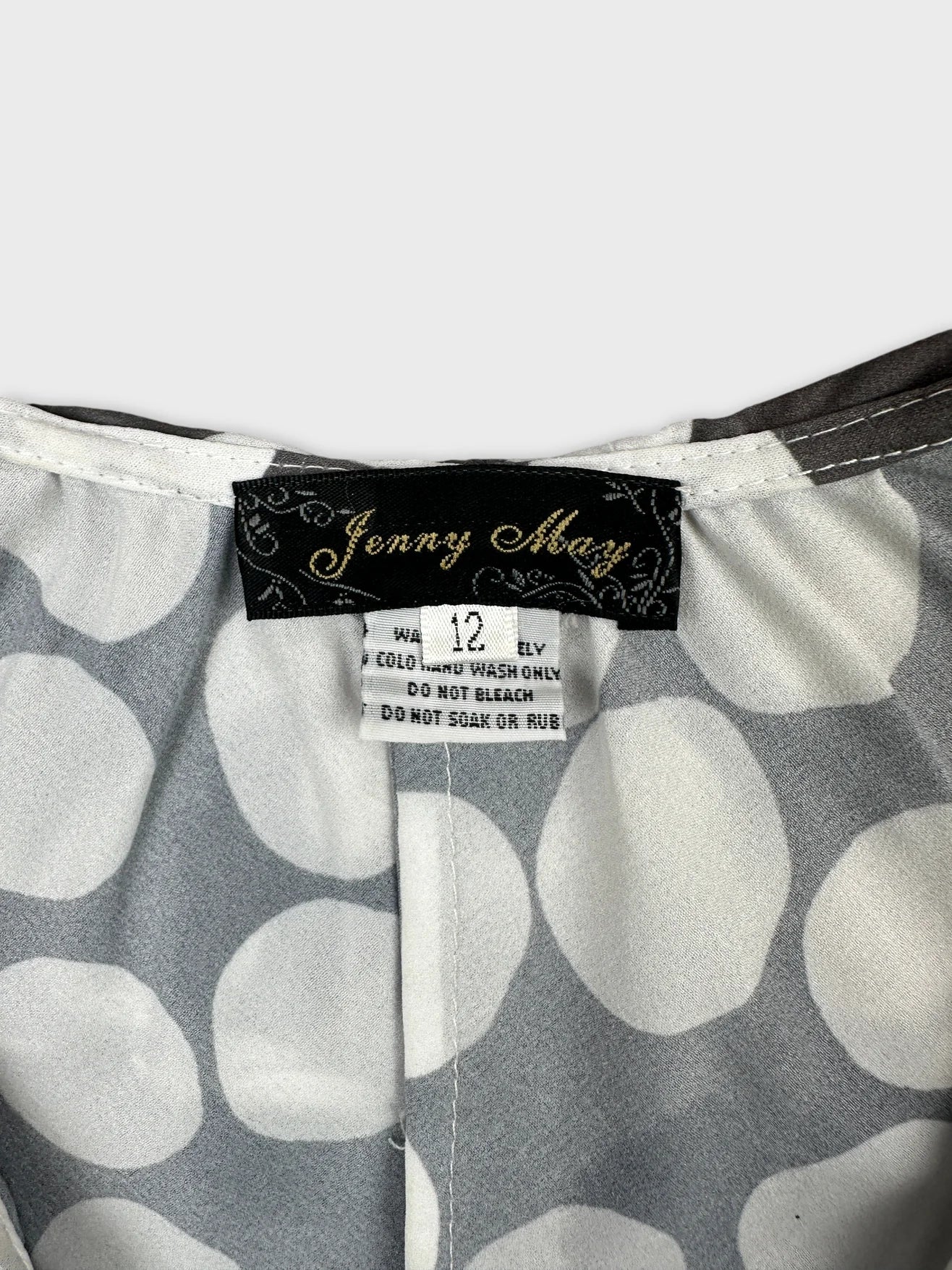 Detail view of a vintage gray top with white polka dots.