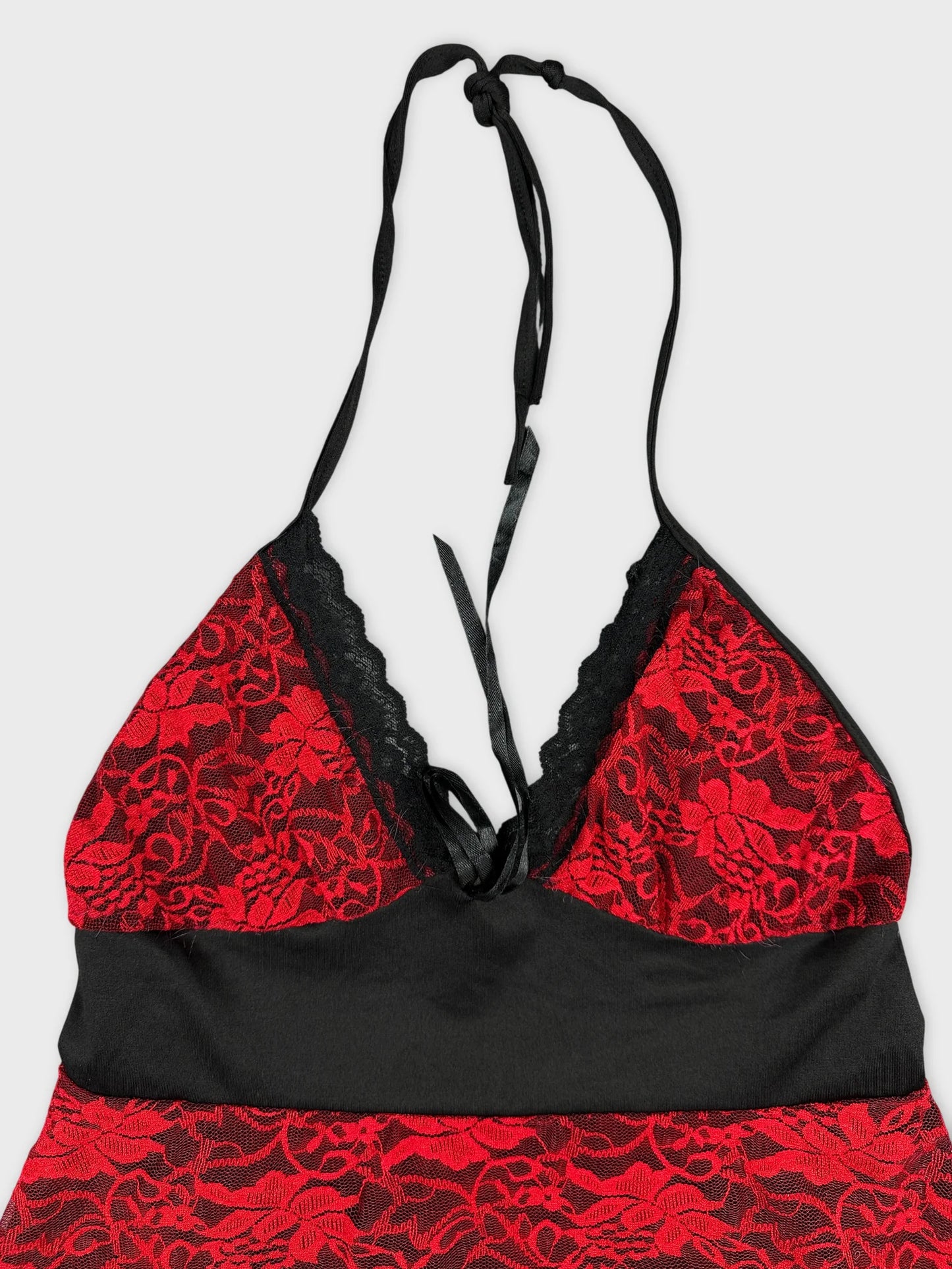 Detail view of a red lace and black top with halter straps.