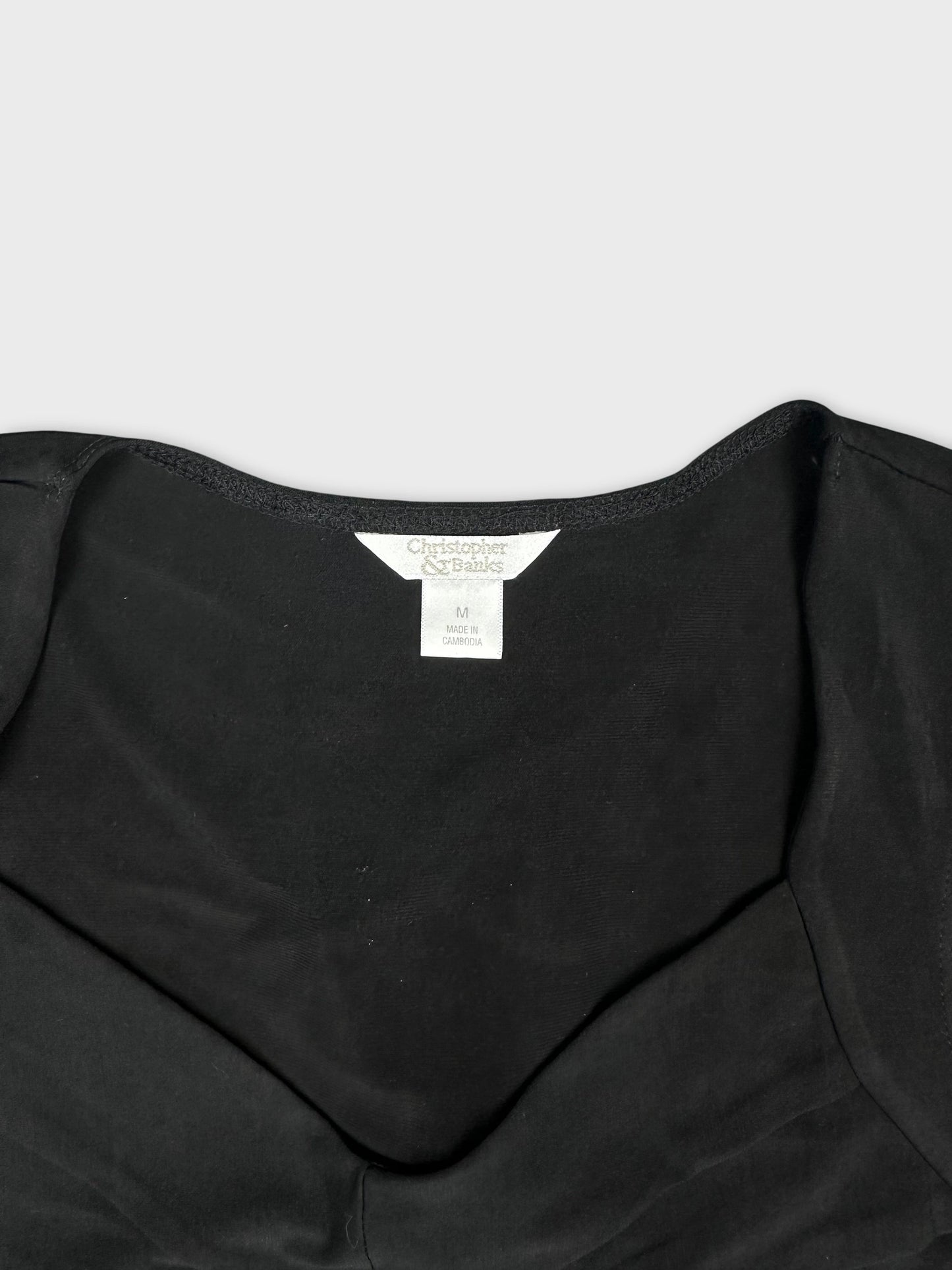Black upper body top with a scoop neckline detail view.