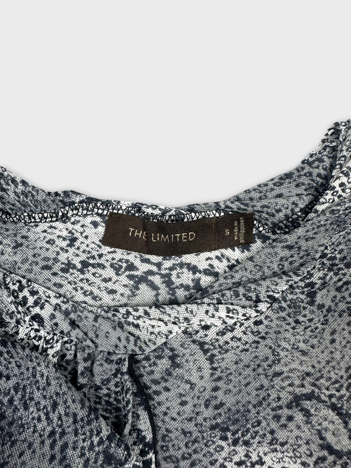 Detail view of a women's top in black and white with a textured pattern.