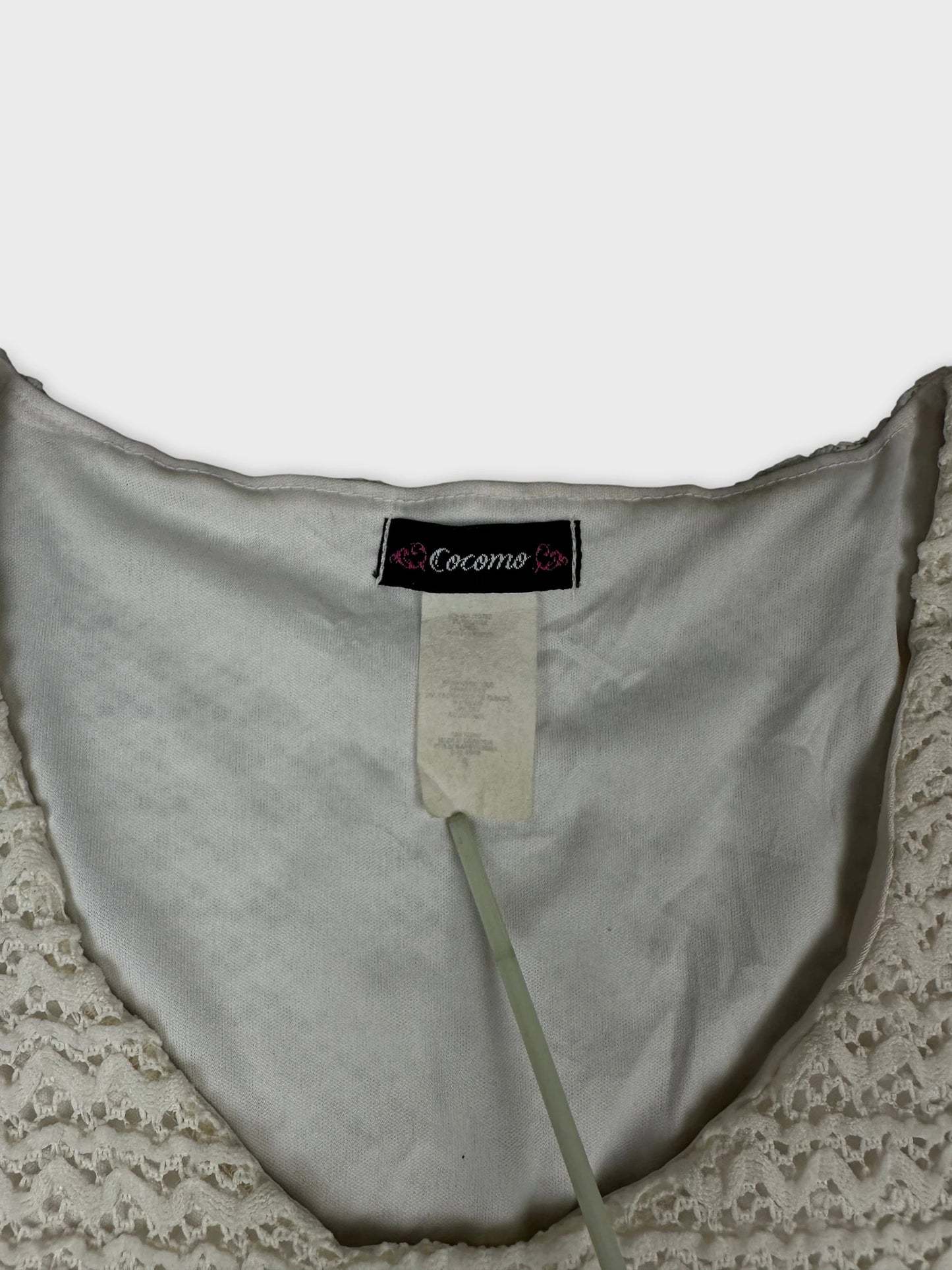 Detail view of a white vintage upper body top with lace trim.