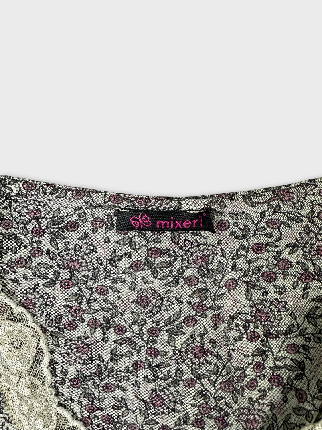 Detail view of a vintage floral top featuring a lace trim