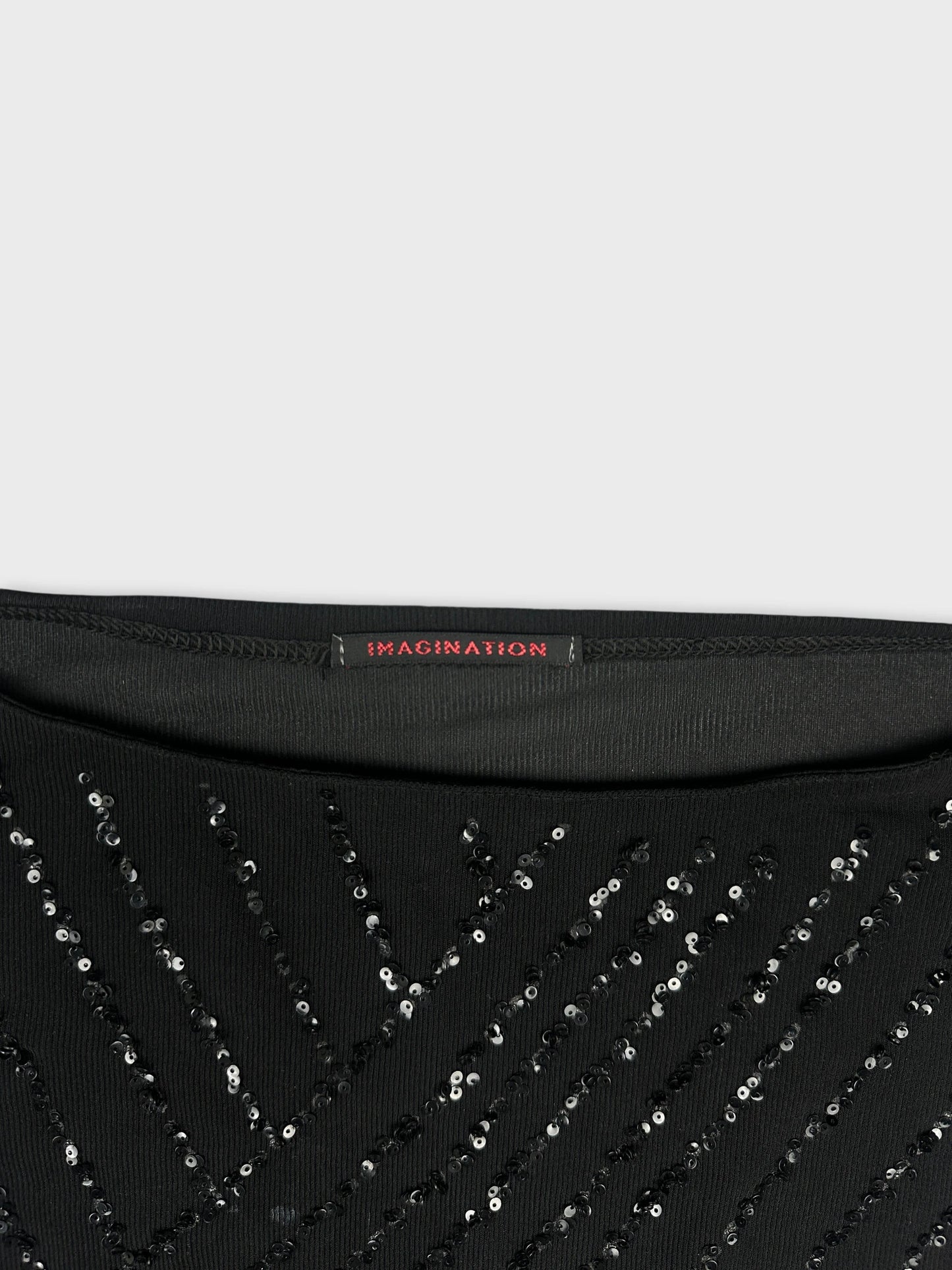 Detail view of black sequined top featuring a chevron pattern.
