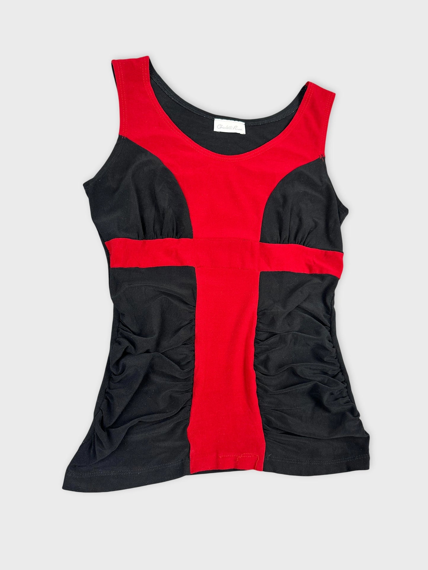 Detail view of a red and black women's top featuring a cross design.