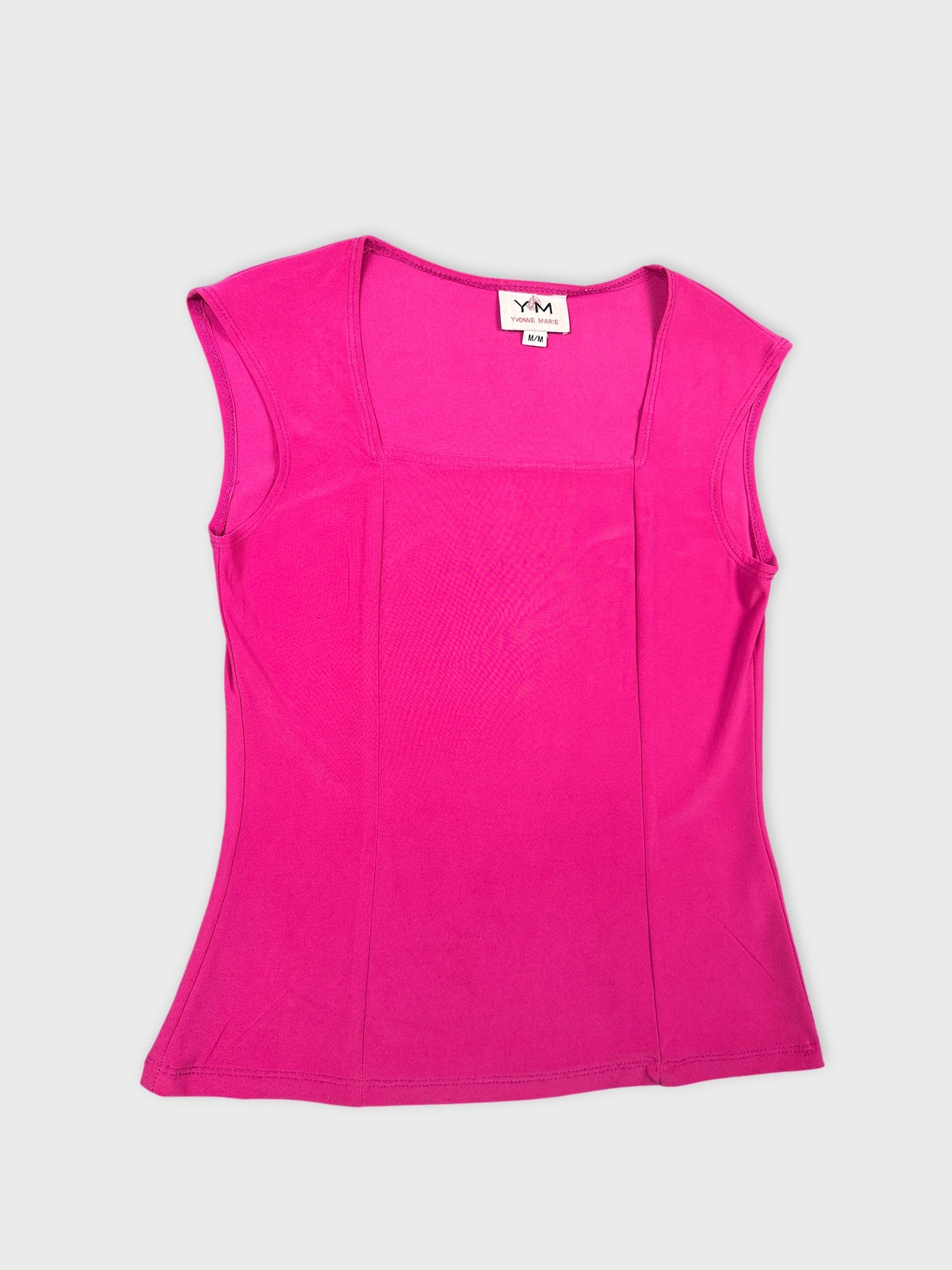 Detail view of a fitted pink sleeveless top with textured pattern.