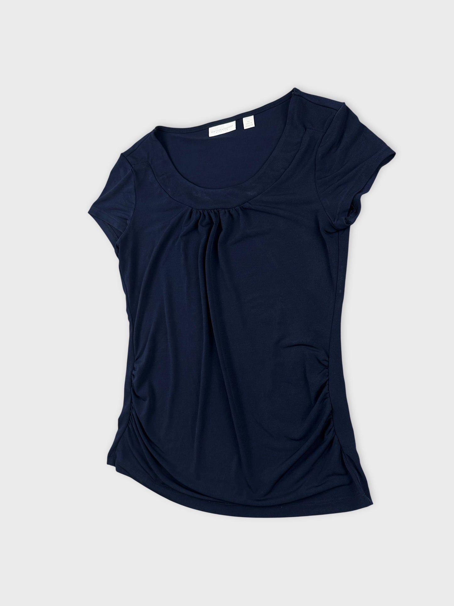 Detail view of a navy blue short-sleeve top featuring gathered sides.