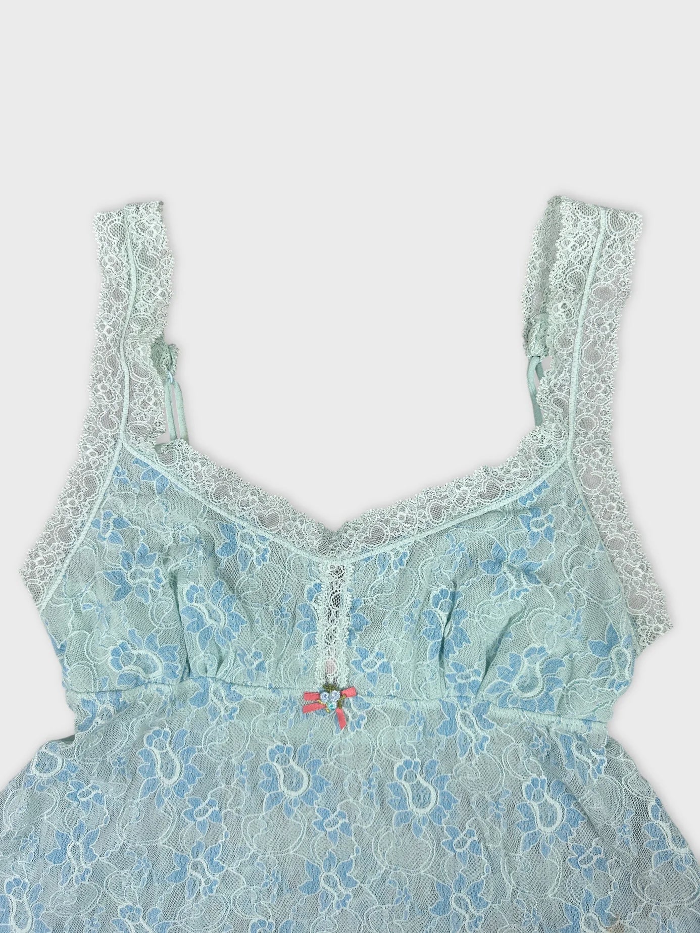 Detail view of a light blue lace women's tank top featuring floral patterns.
