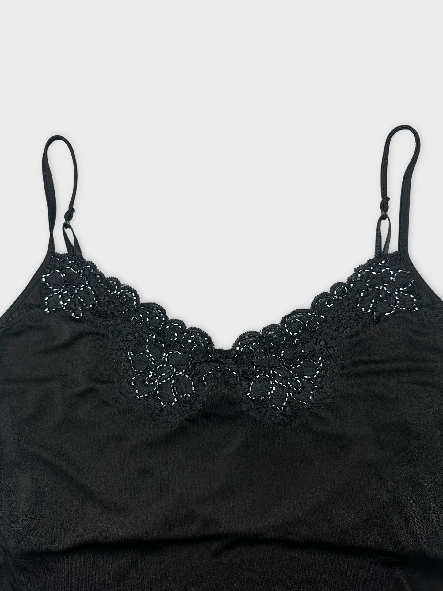 Detail view of a black camisole top with lace trim.