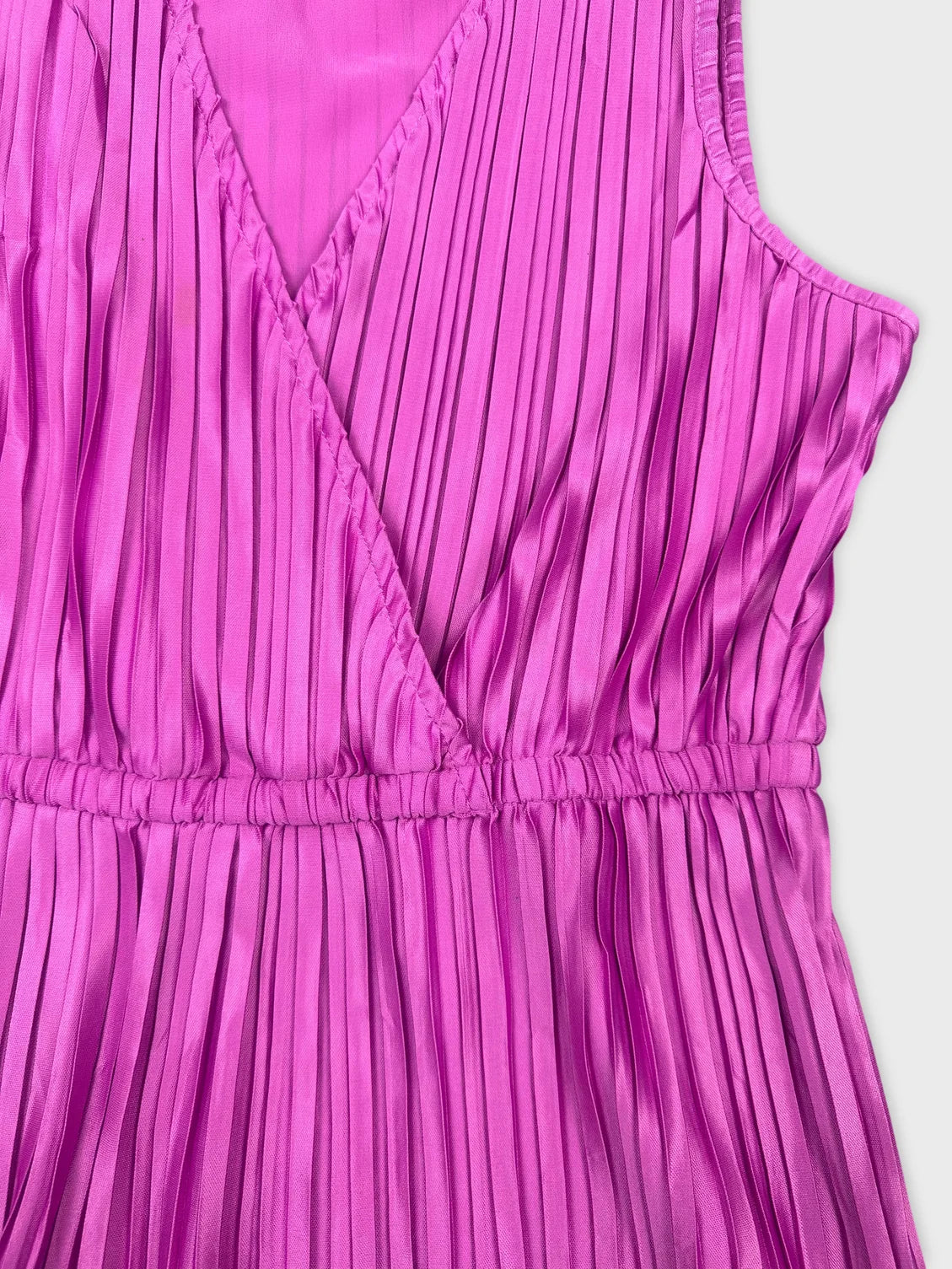 Detail view of a pleated pink women's top with a v-neckline.