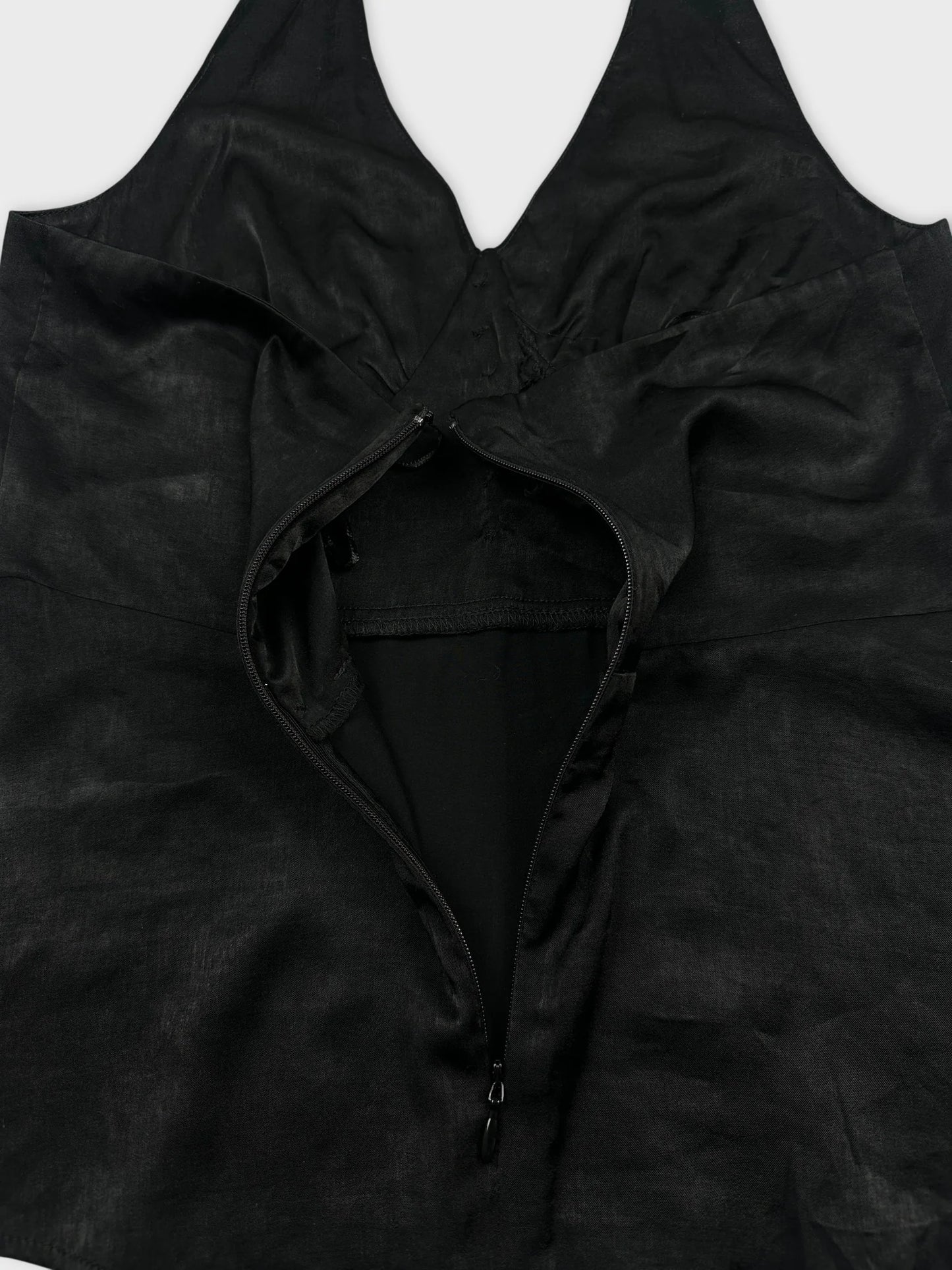 Black top detail view featuring a zip closure and halter neckline.