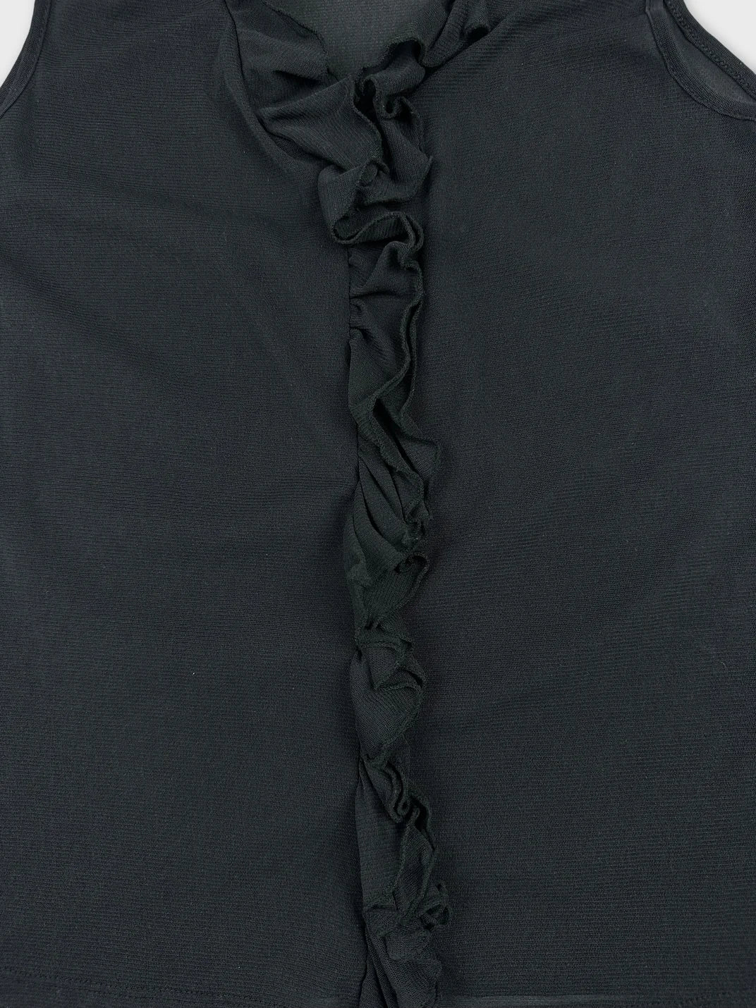 Detail view of a black upper body top with ruffled trim.