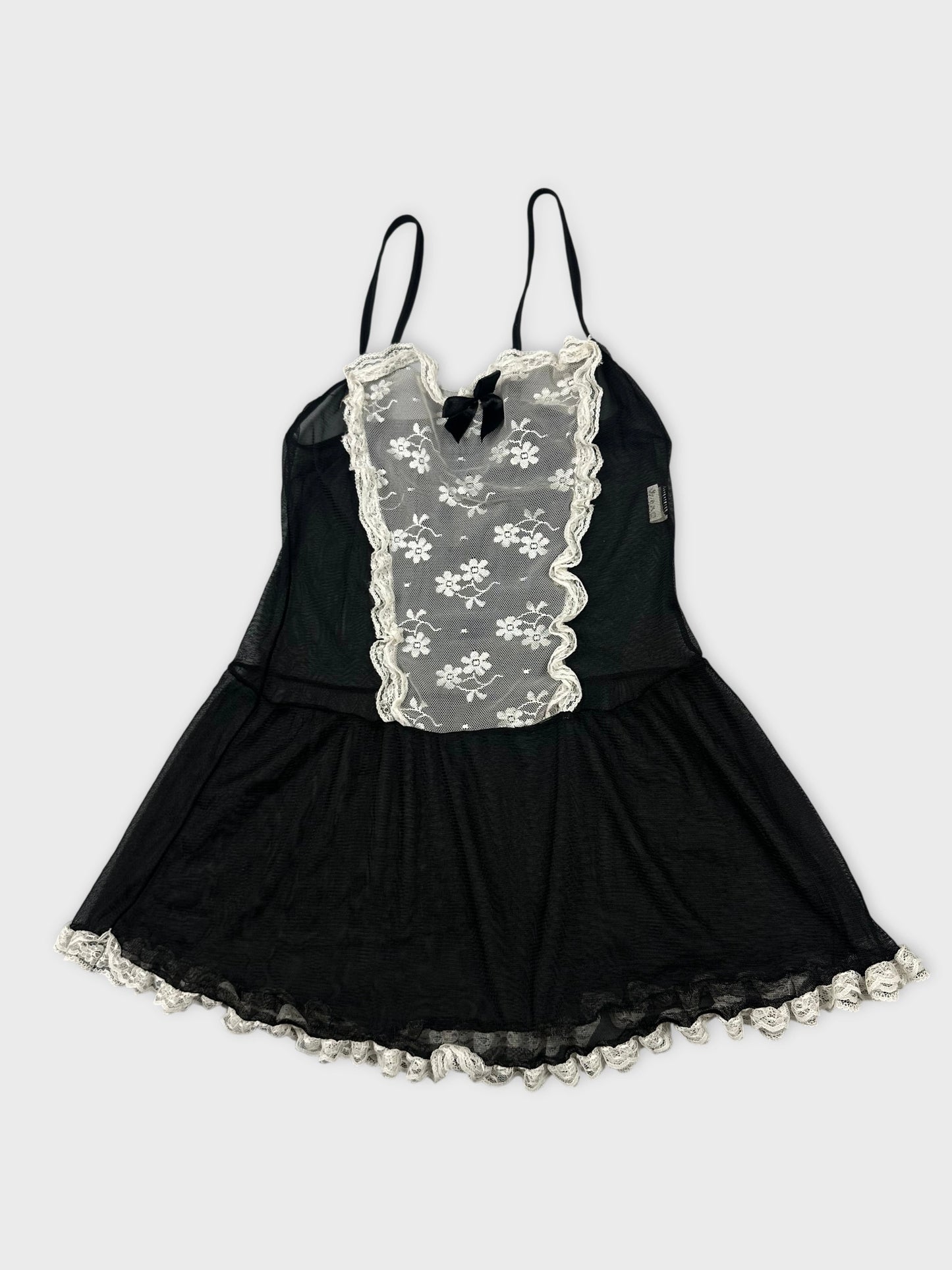 Detail view of a black vintage top featuring lace trim and floral mesh.