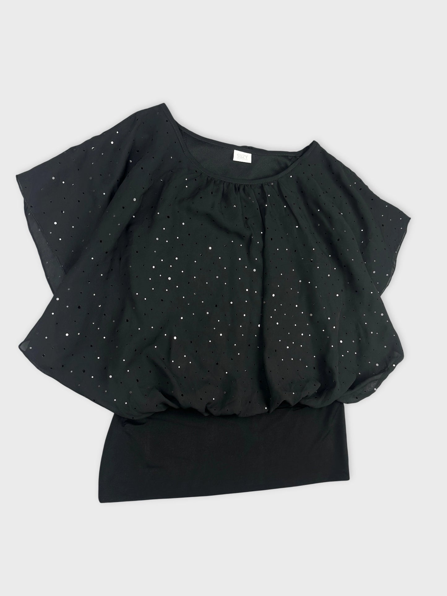 Detail view of a black top with silver dot pattern and flowy sleeves.