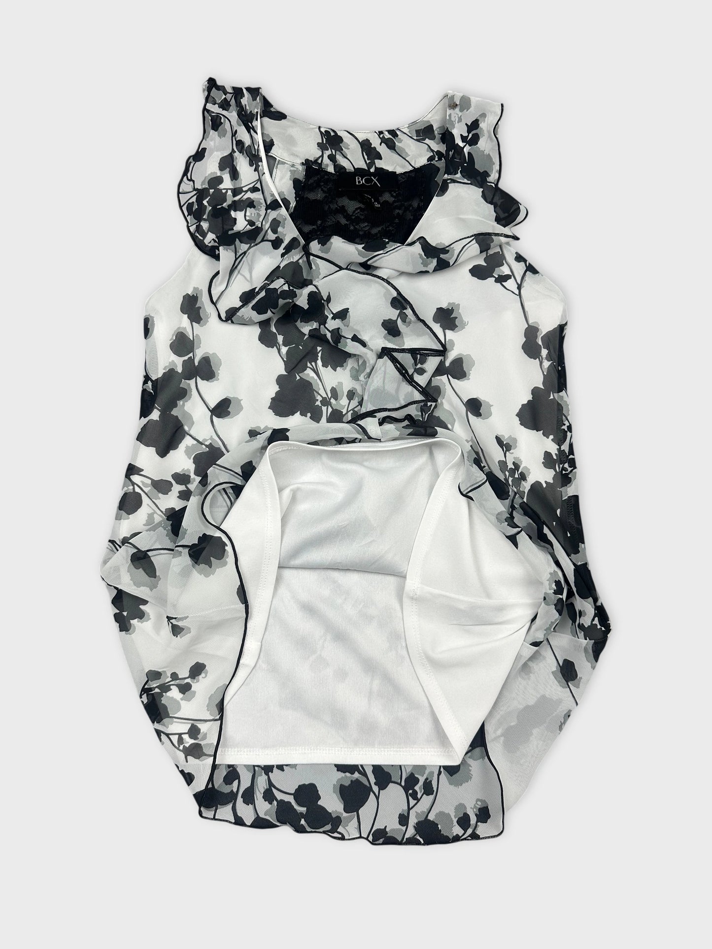 Detail view of a black and white floral ruffled tank top.