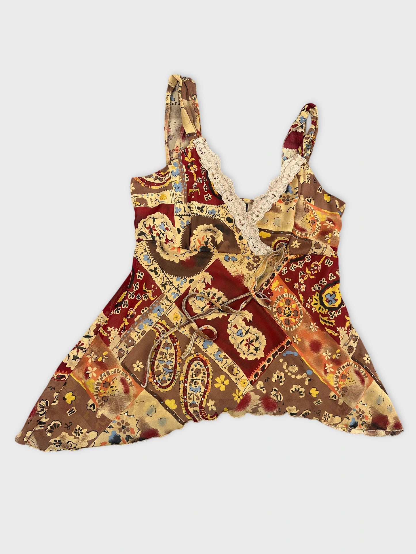 Detail view of a vintage top featuring a multi-color floral patchwork design.