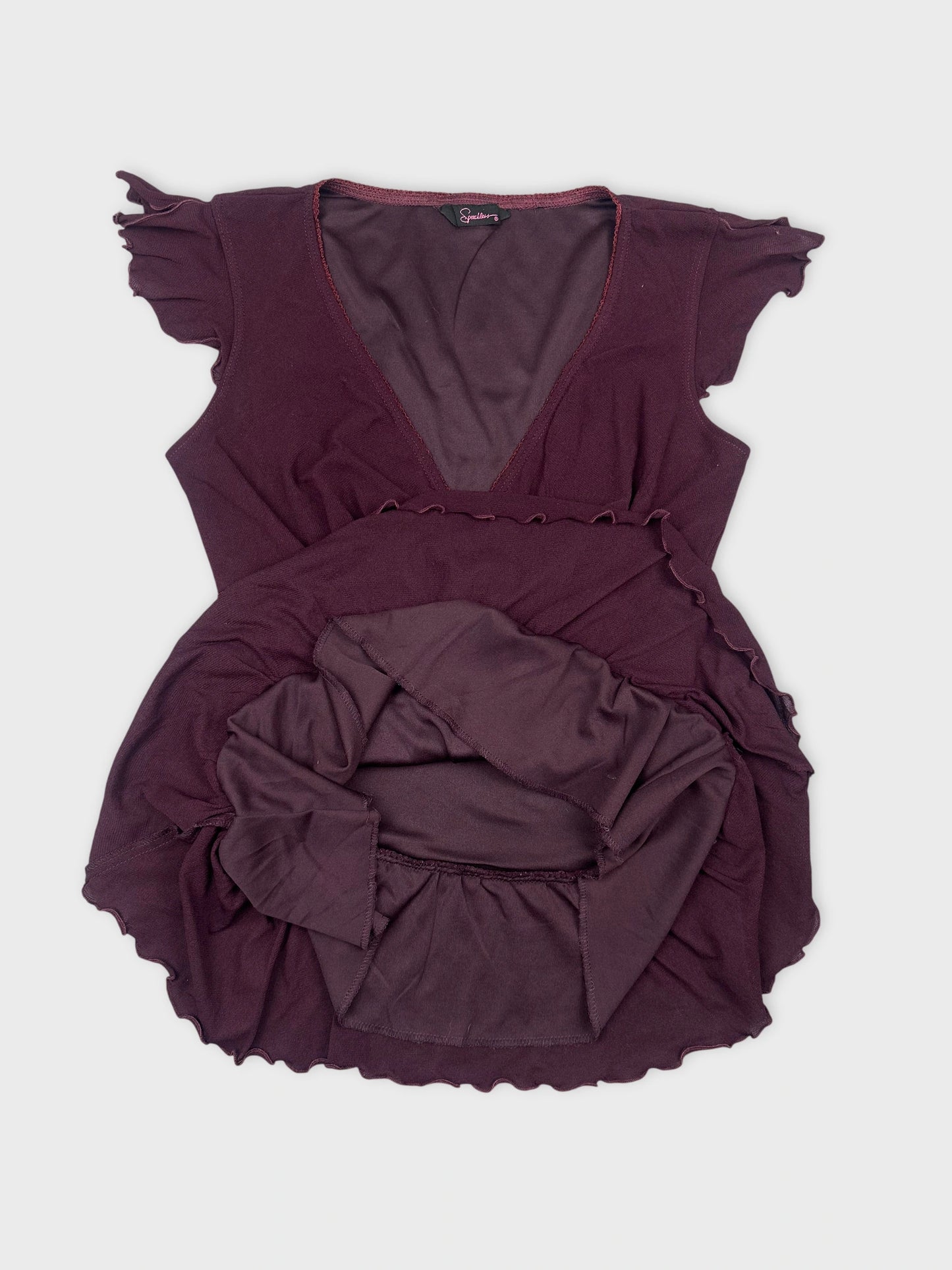 Detail view of a burgundy women's top with ruffled sleeves.