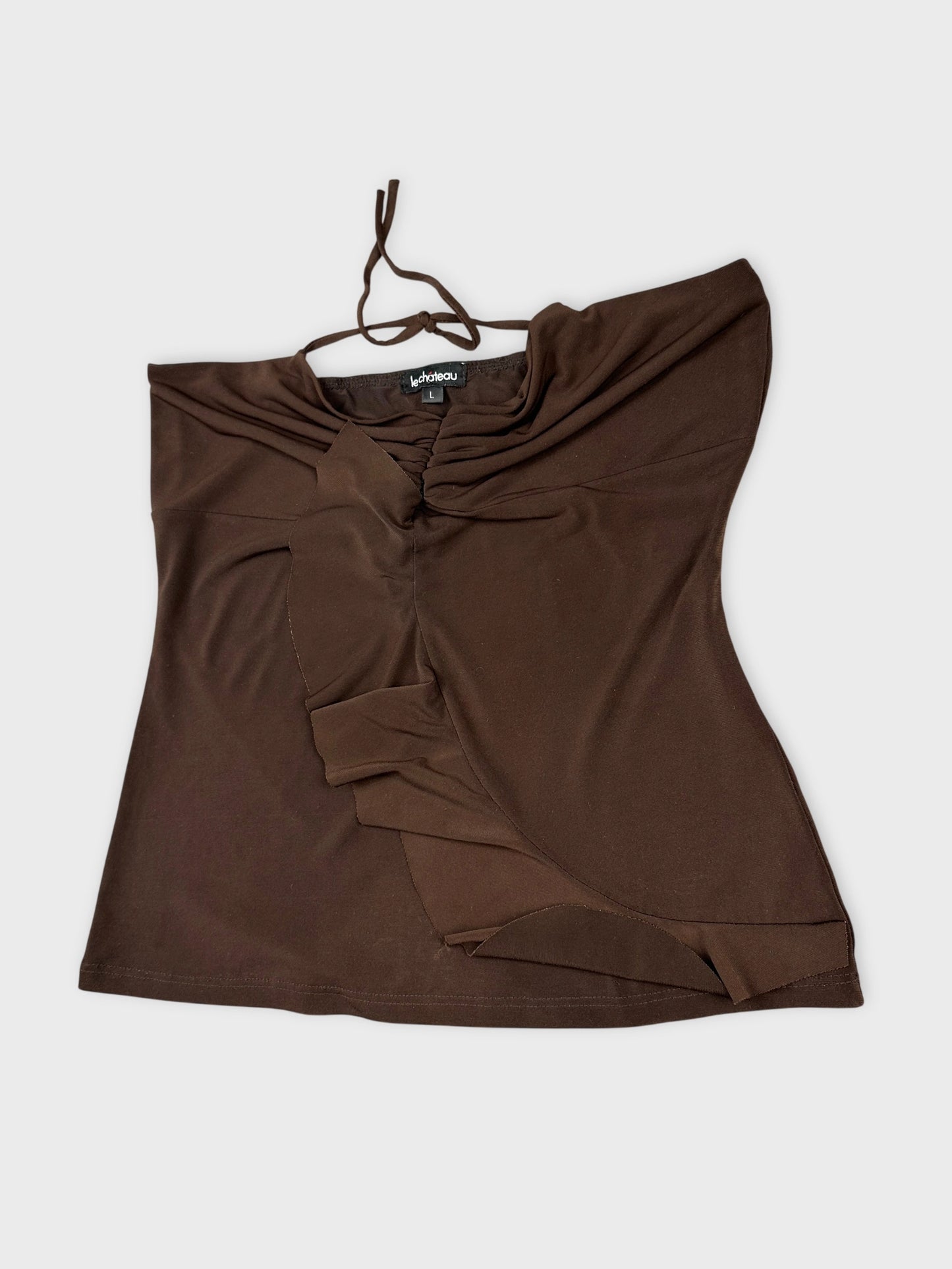 Detail view of a brown upper body top with draped fabric design.