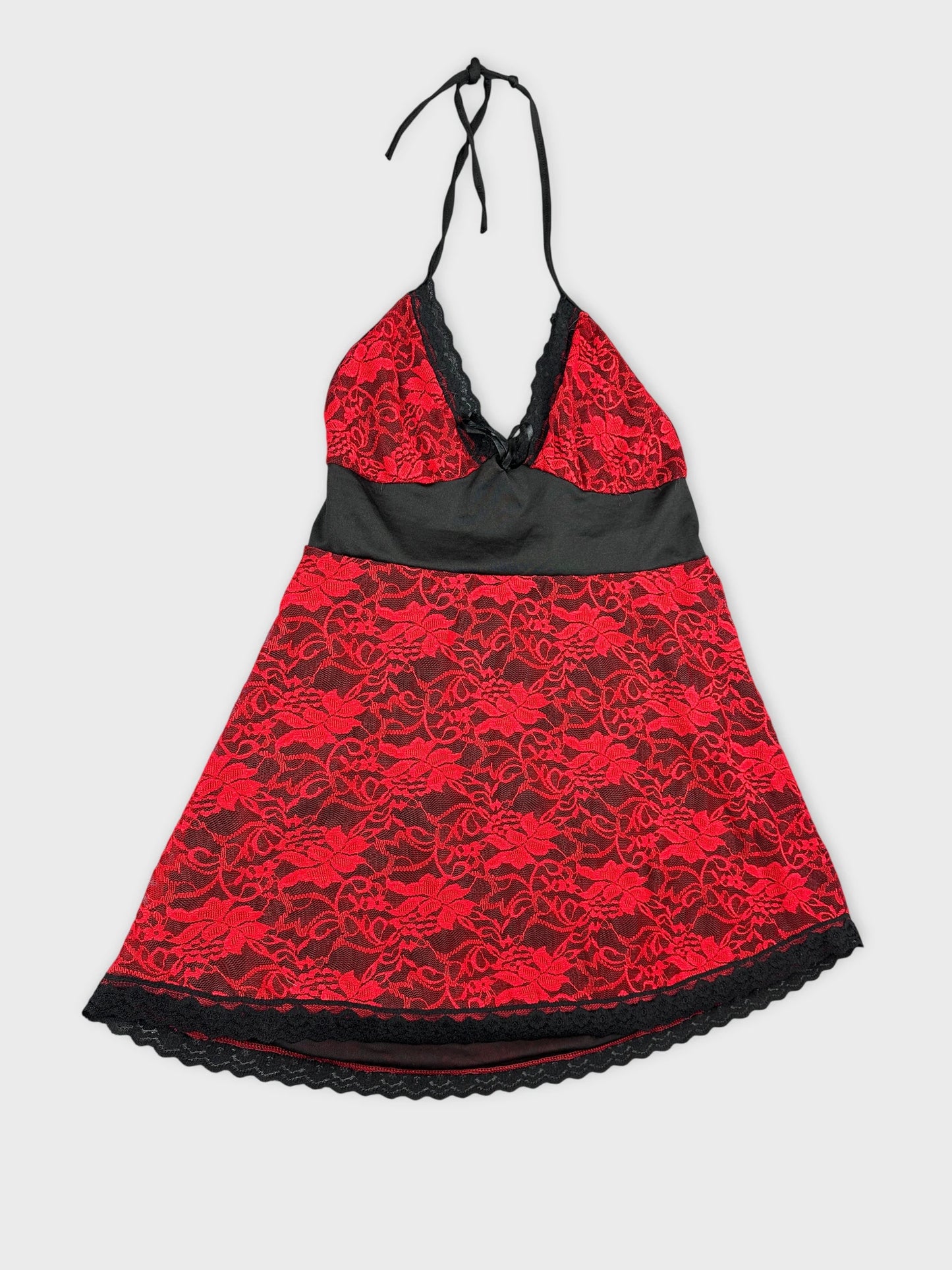 Detail view of a red lace halter top with black trim.