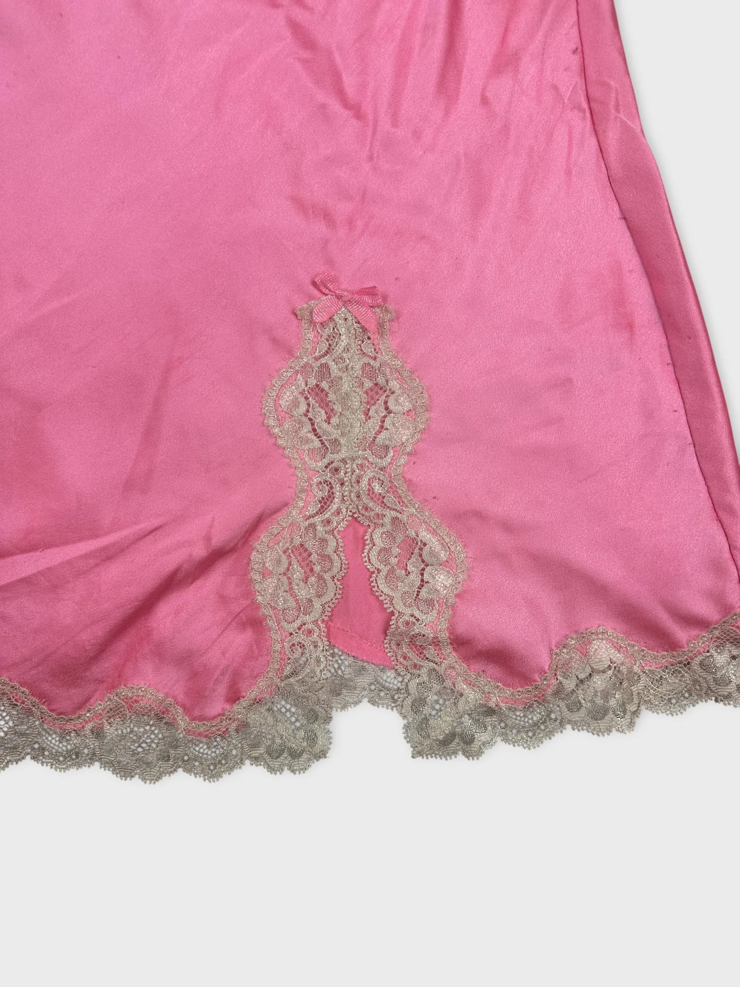 Detail view of a pink women's top featuring intricate lace trim.