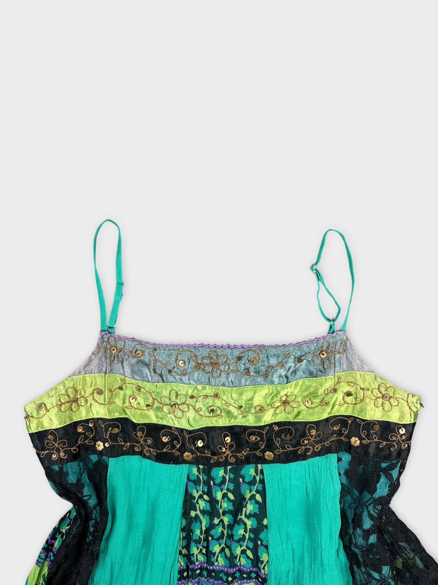 Detail view of a vintage turquoise top featuring embroidered lace trim.