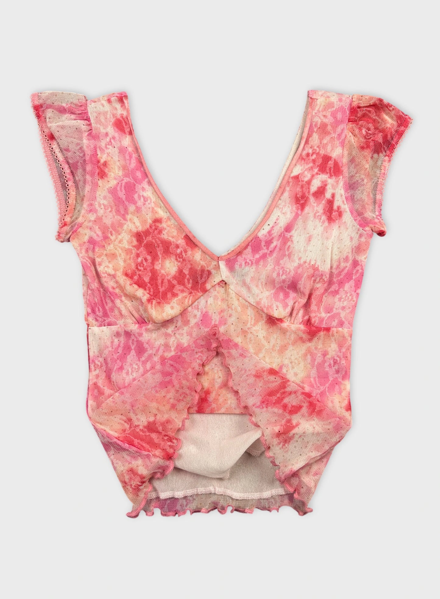 Detail view of a pink tie-dye women's upper body top with scalloped trim.