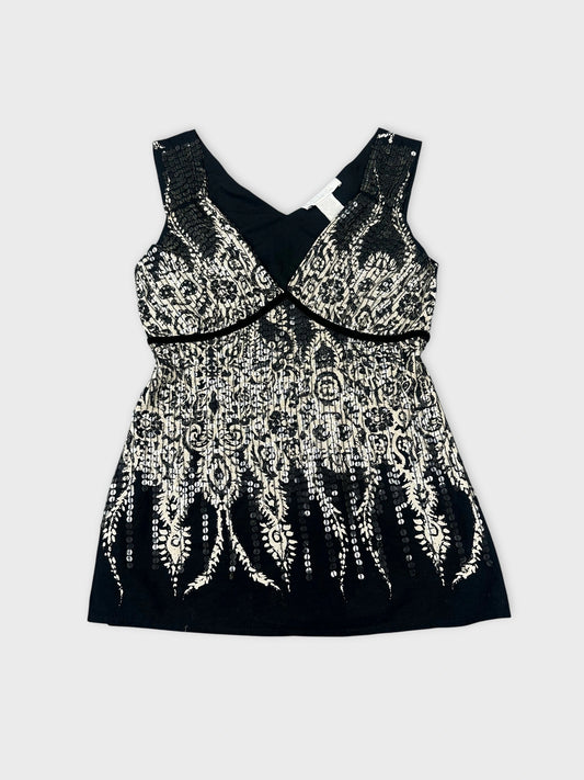 Front view of a black and white embellished tank top with lace pattern.