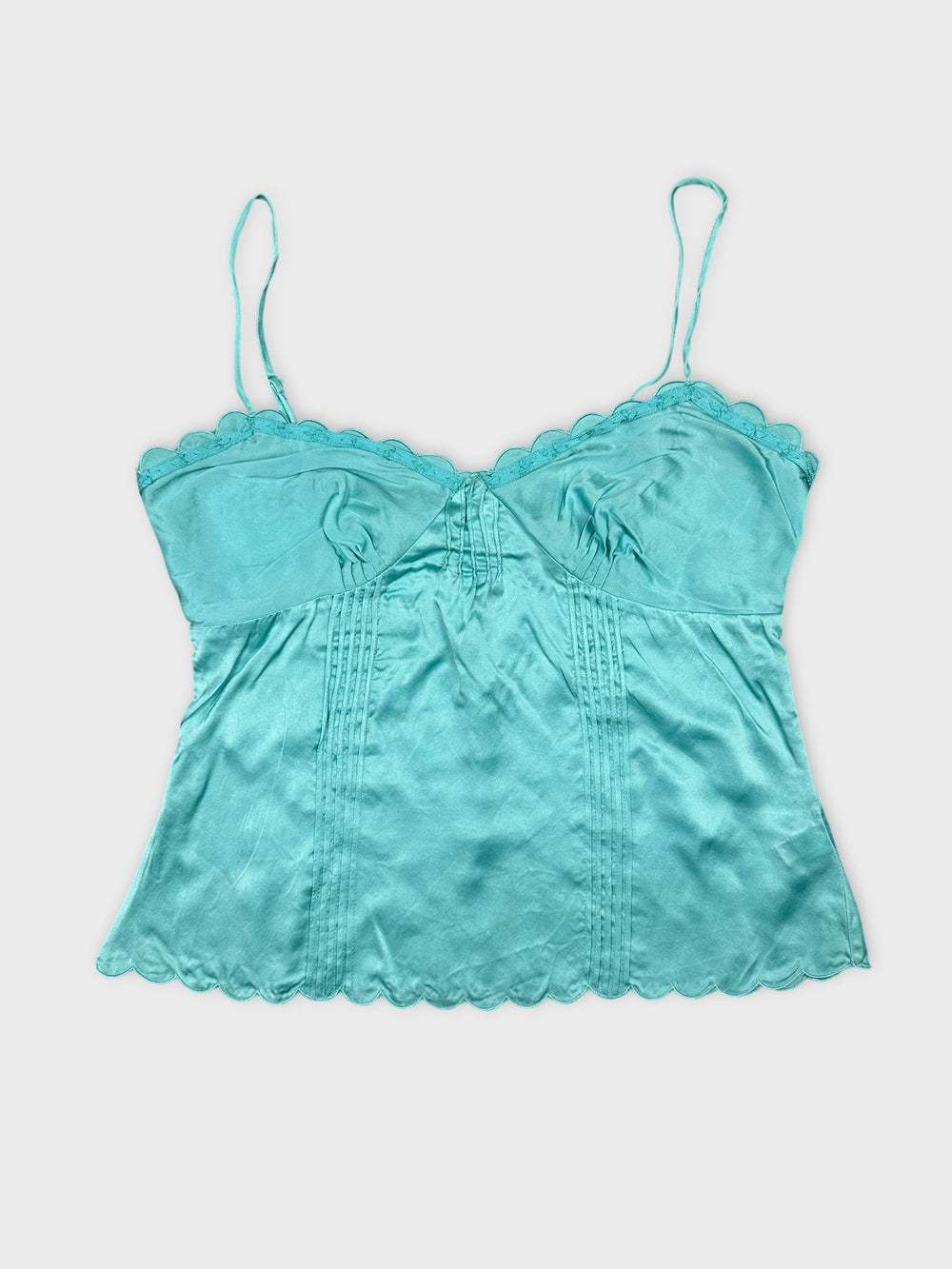 Front view of a turquoise vintage camisole with scalloped trim.