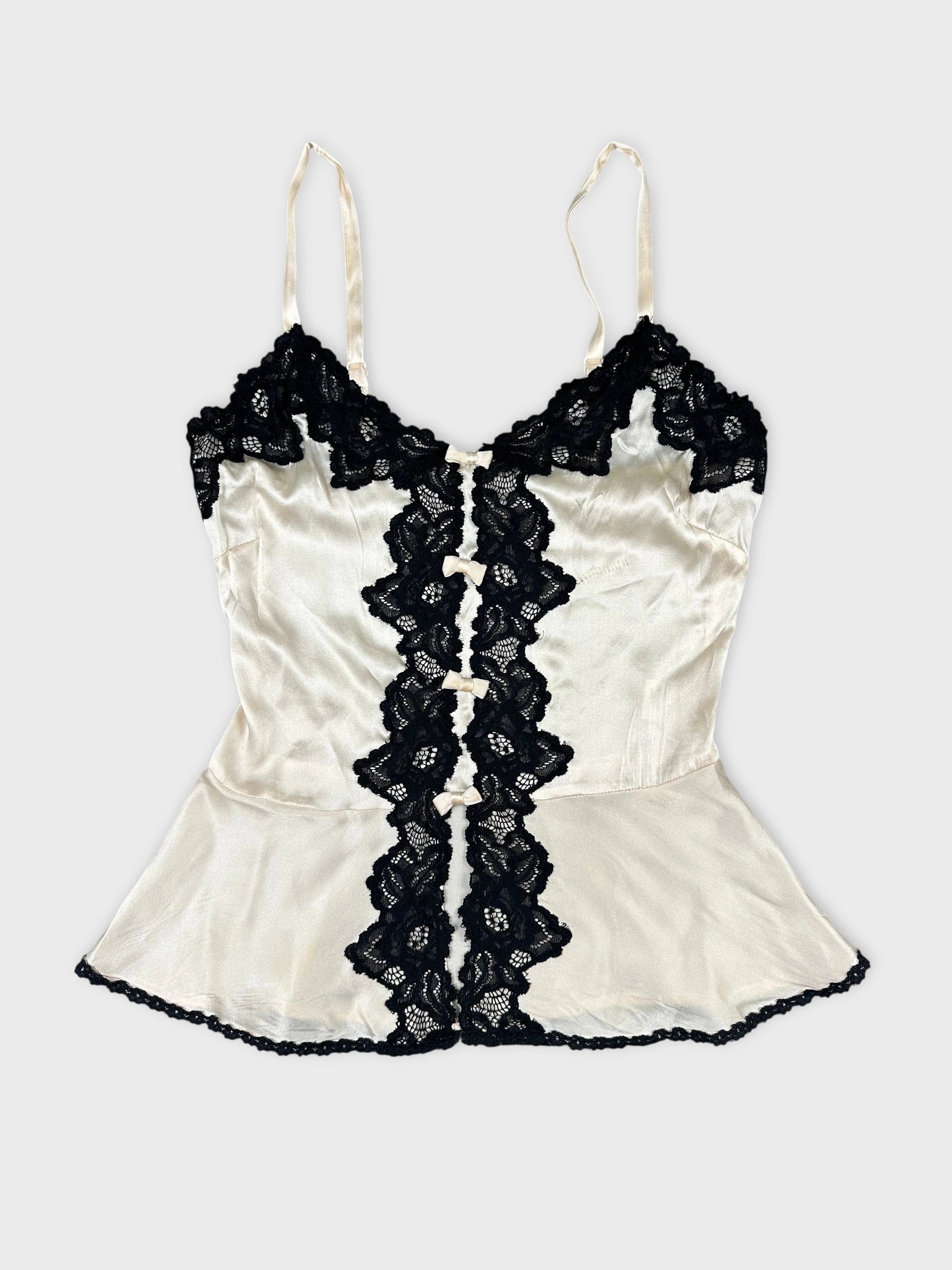 Front view of a cream silk top with black lace trim.
