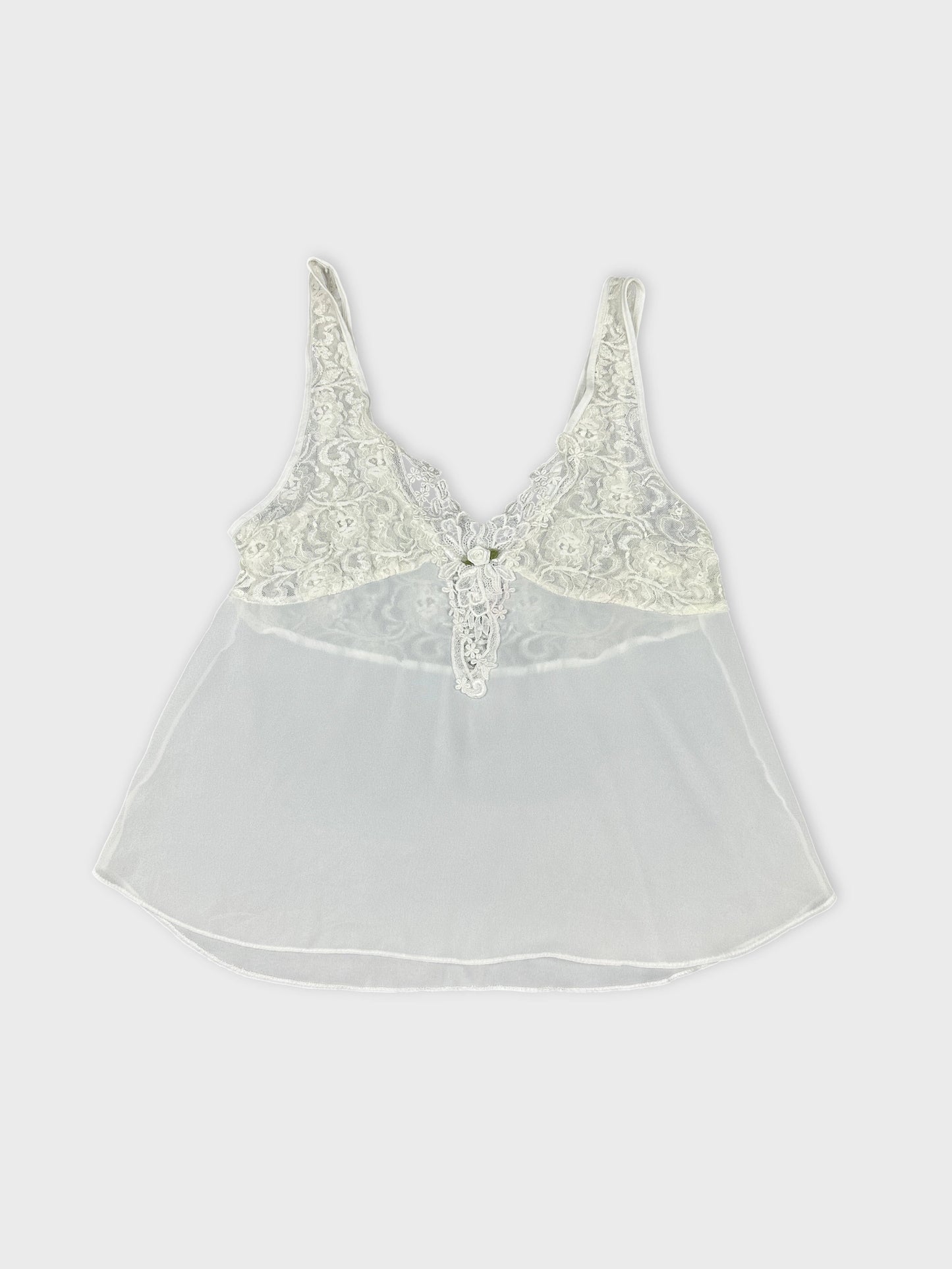Front view of a white lace-trimmed sleeveless top with intricate detailing.