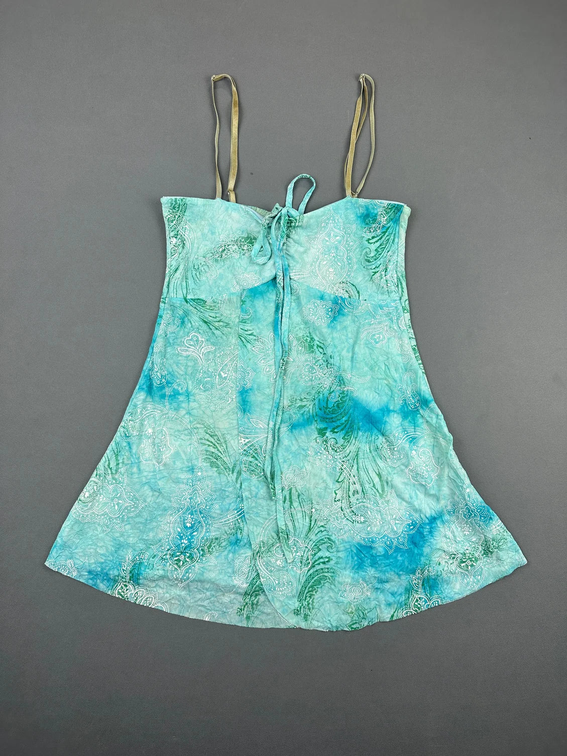 Front view of a light blue vintage top featuring a paisley pattern and ties.