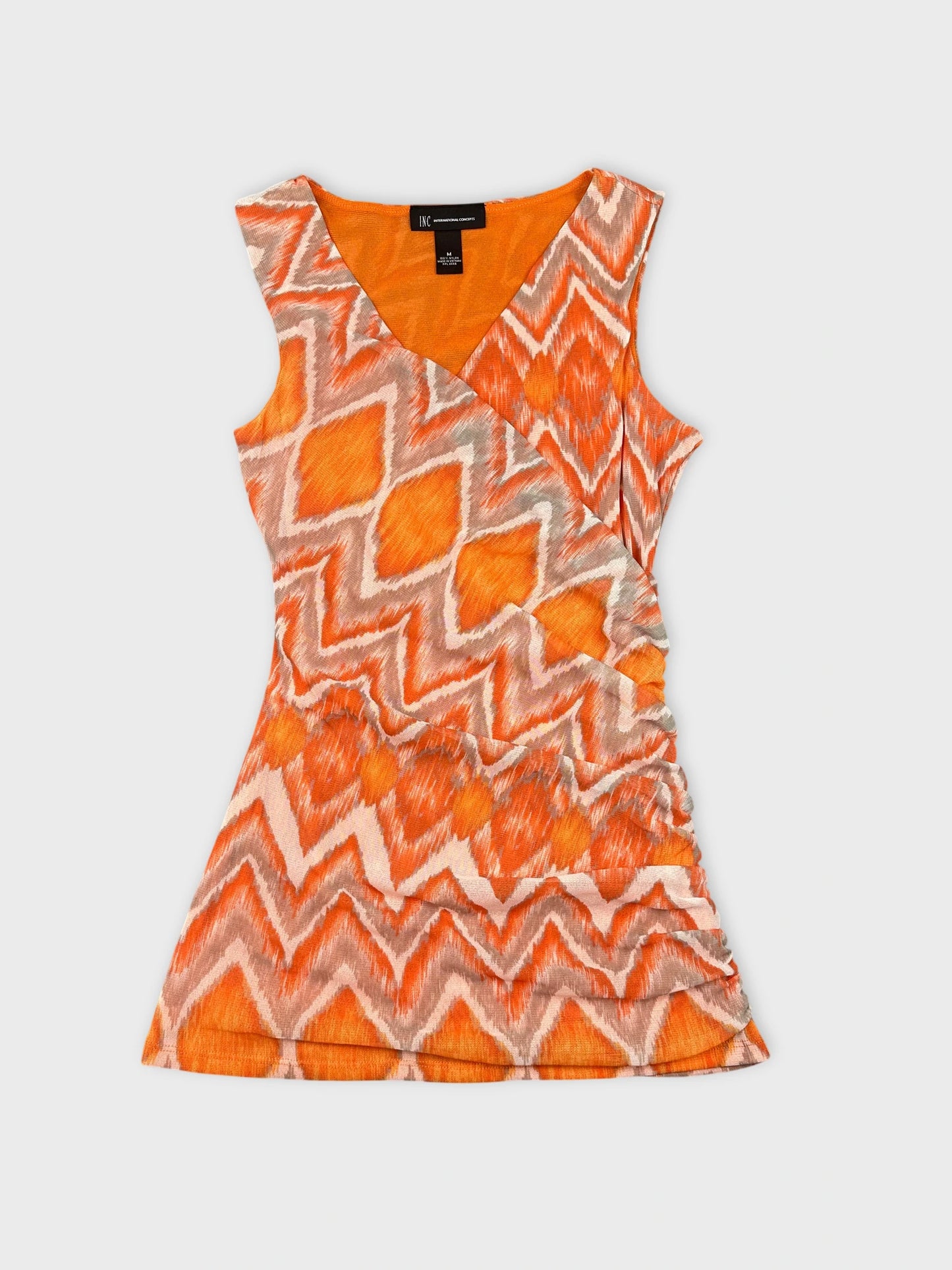 Front view of an orange patterned sleeveless top featuring zigzag design.