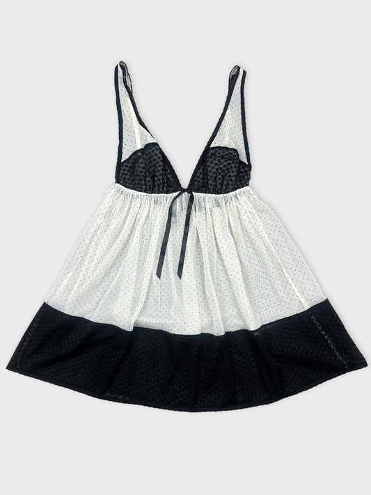 Front view of a black and white polka dot top with a tie detail.