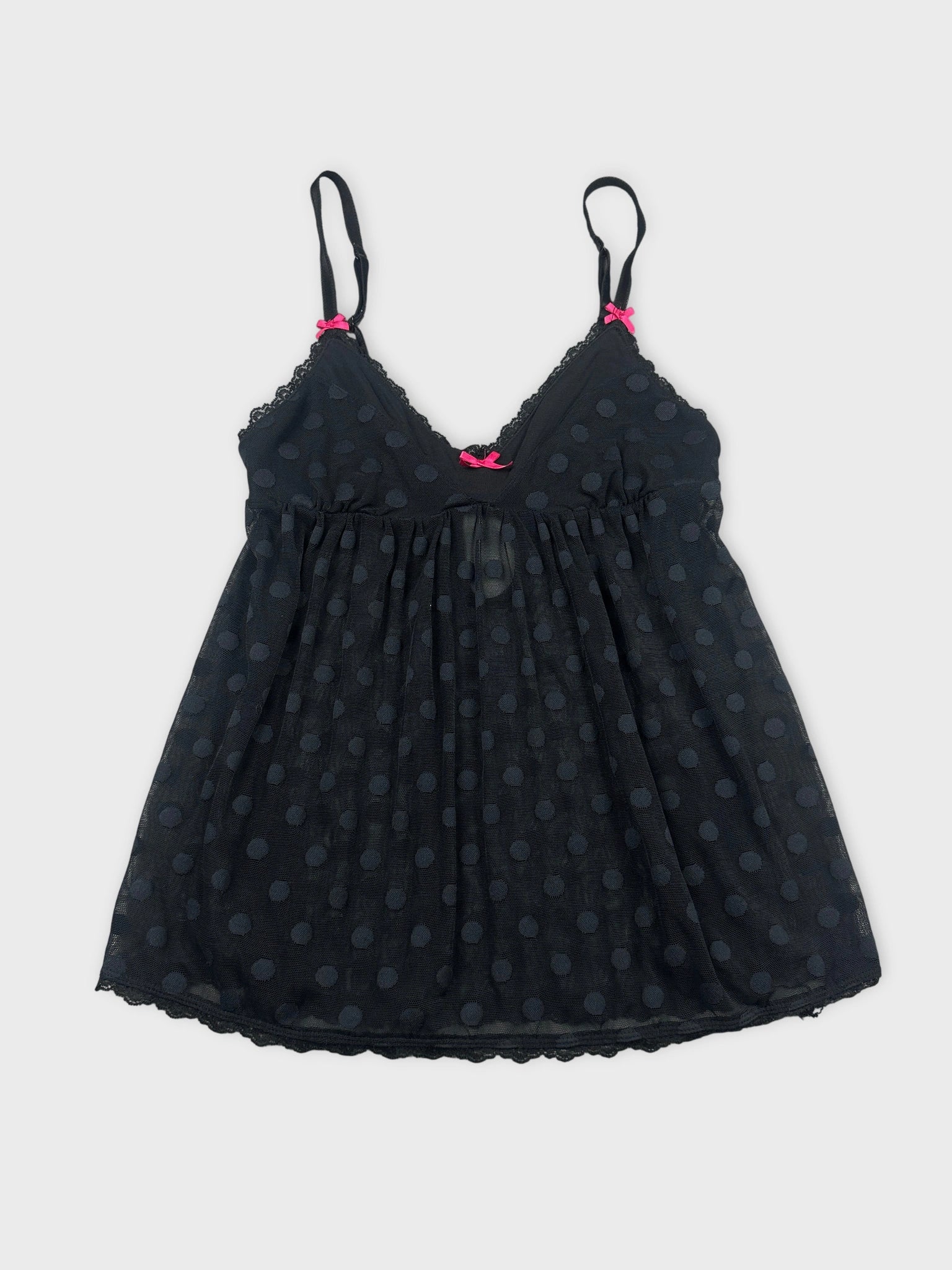 Front view of a black polka dot tank top with pink bows.