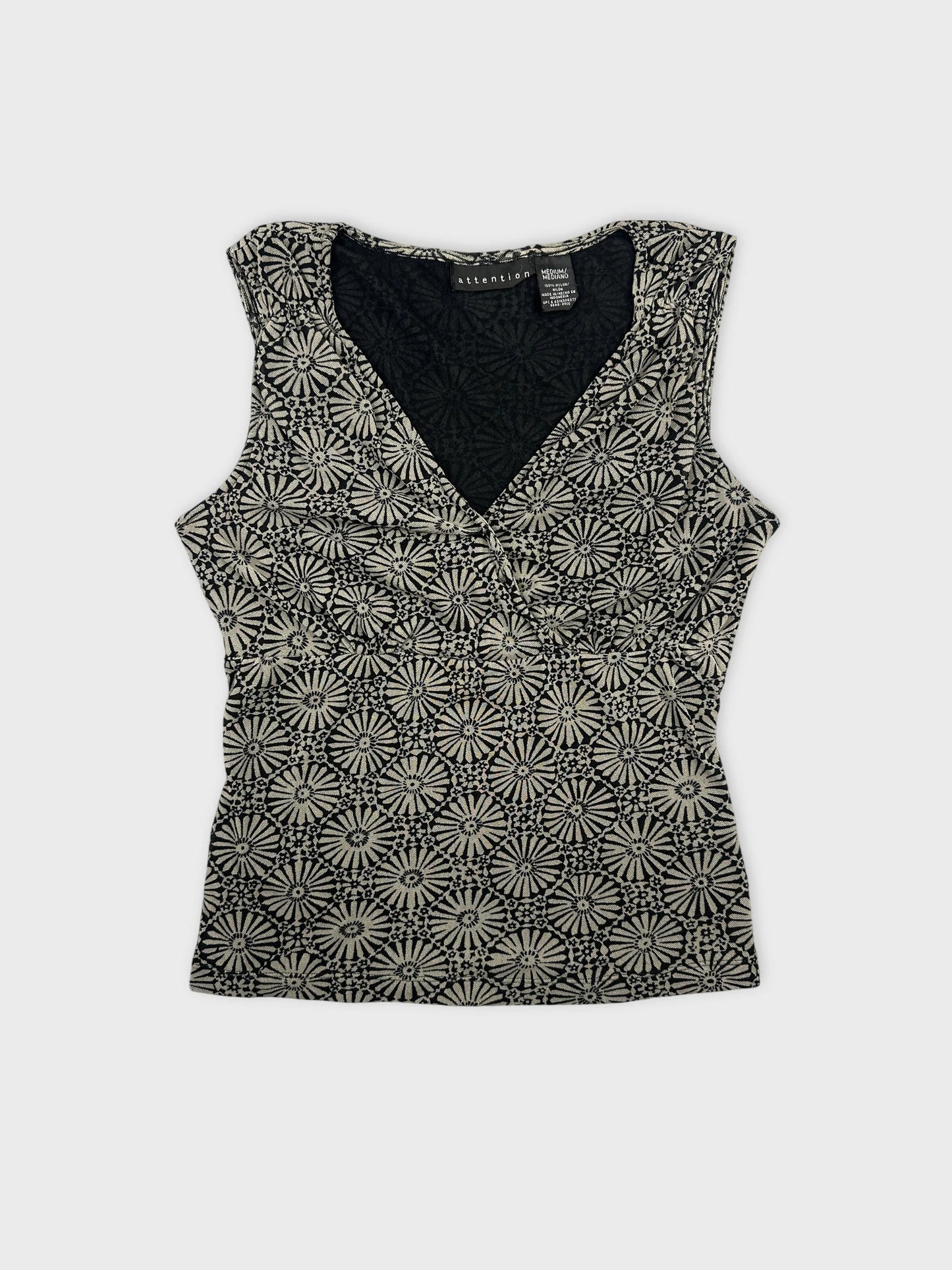 Black and cream floral print top in front view.