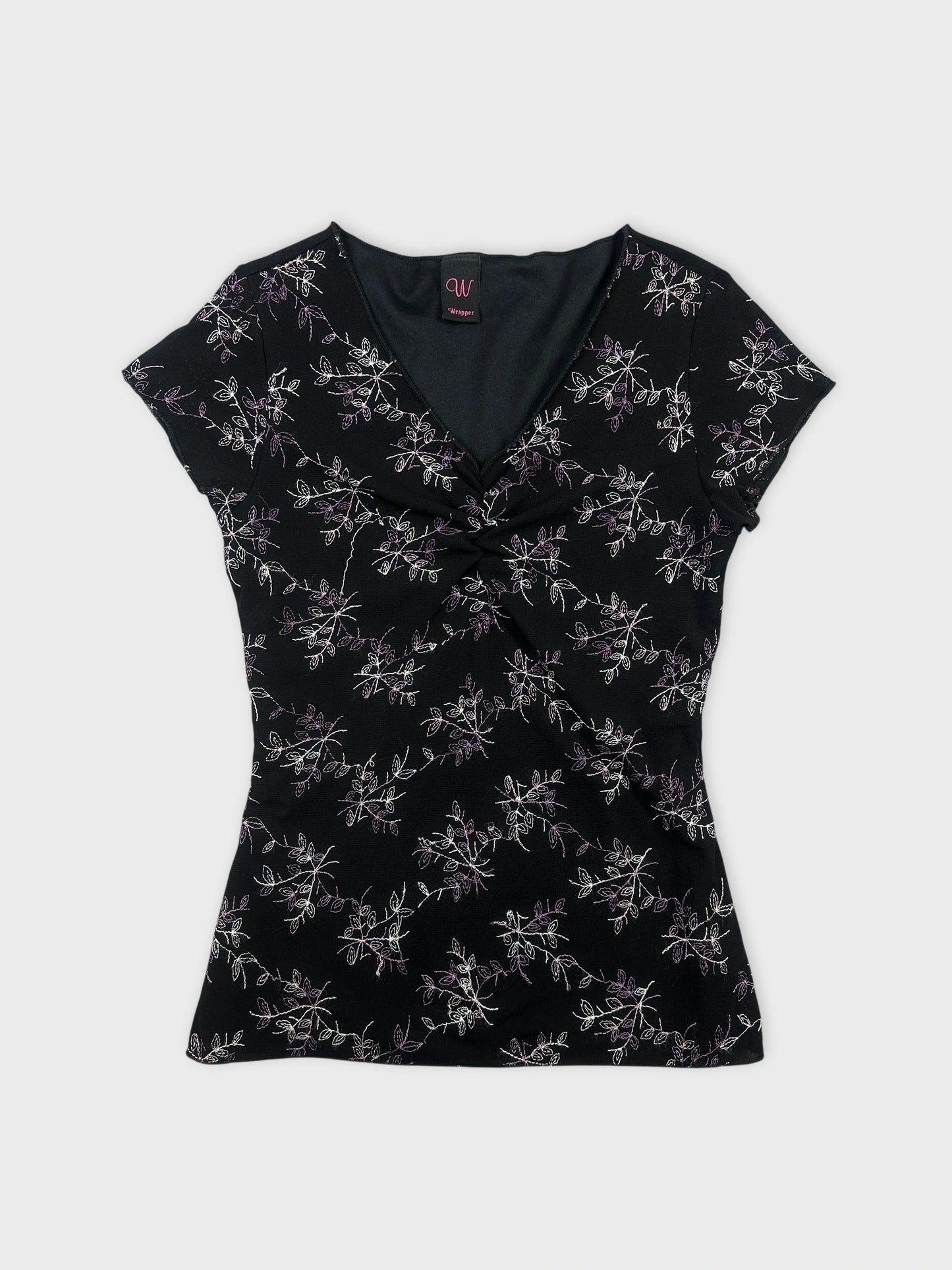 Front view of a black top featuring floral embroidery at the front.