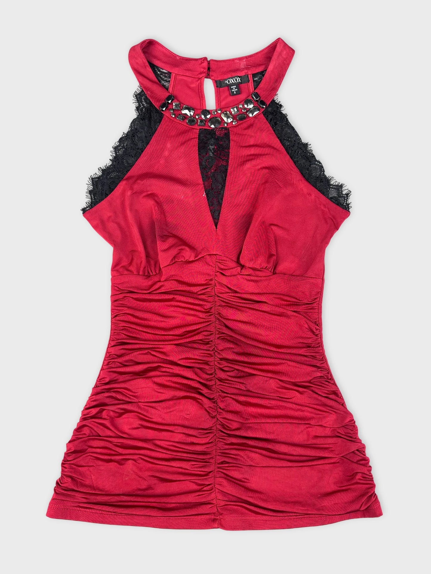 Front view of a red halter top featuring lace and ruched detailing.