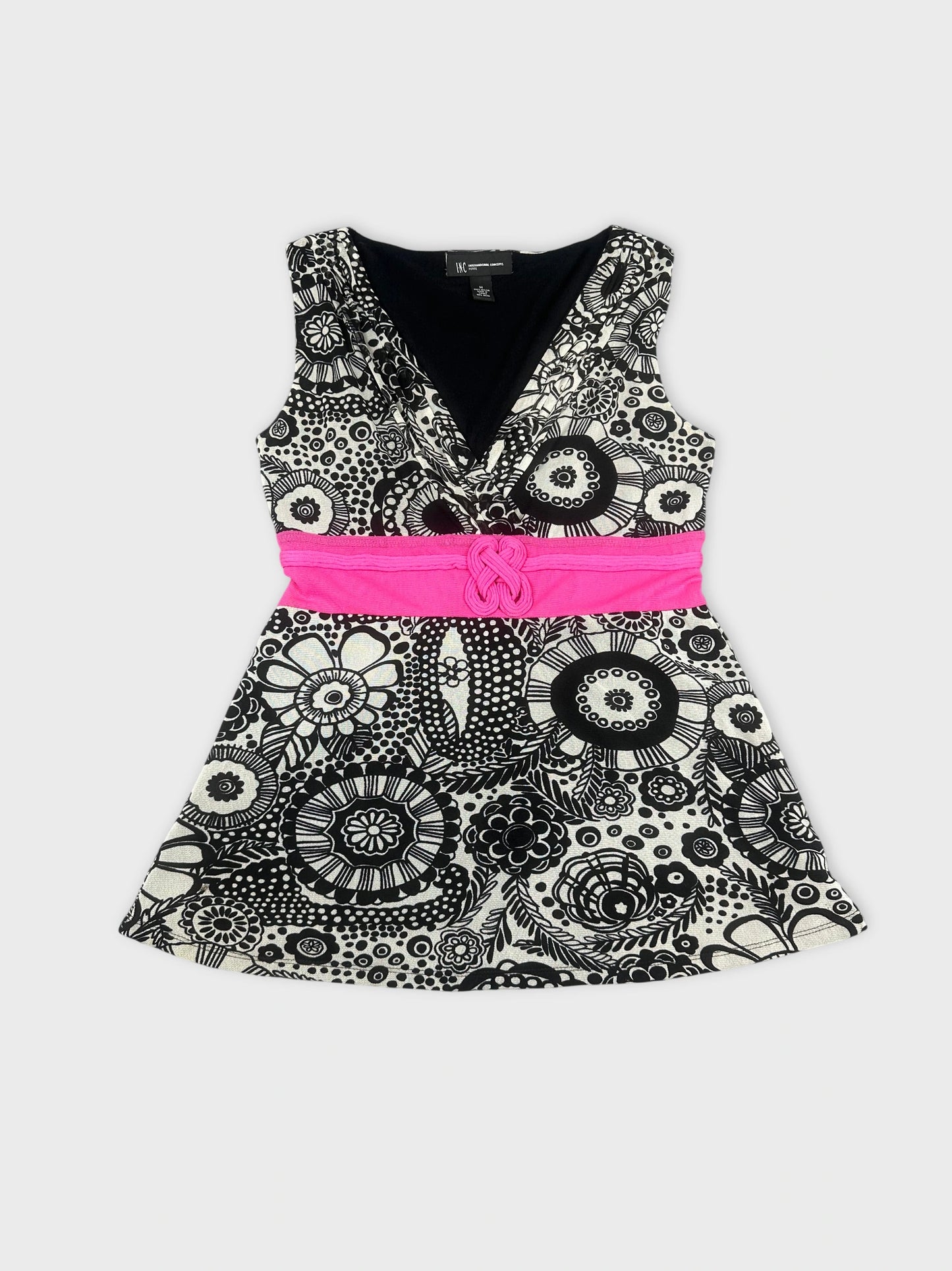 Front view of a black and white patterned dress with a pink belt.