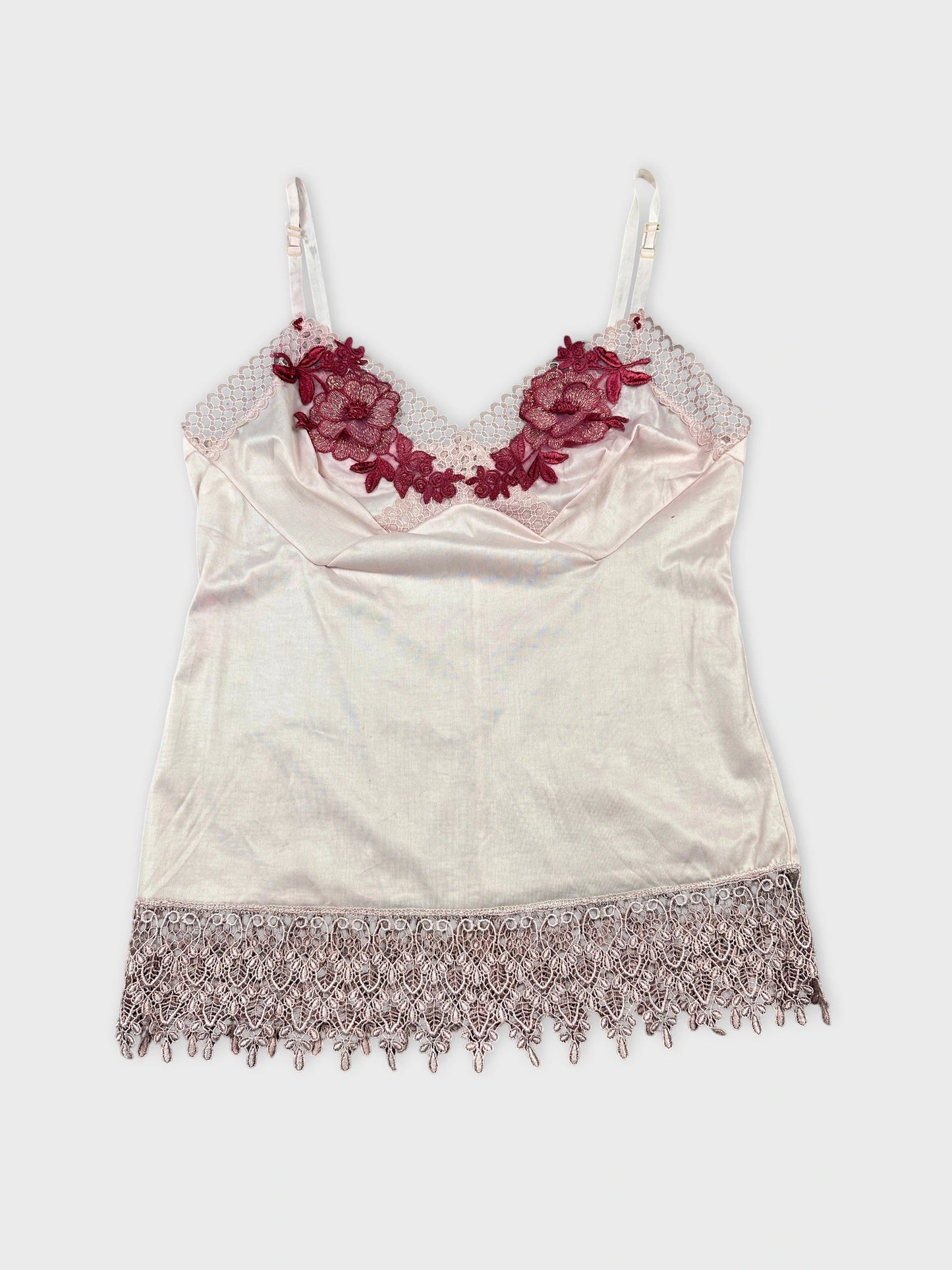Front view of a vintage women's camisole in pale pink with intricate burgundy lace trim.