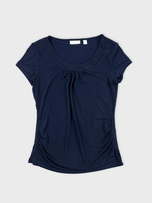 Front view of a navy blue top with gathered detailing on sides.