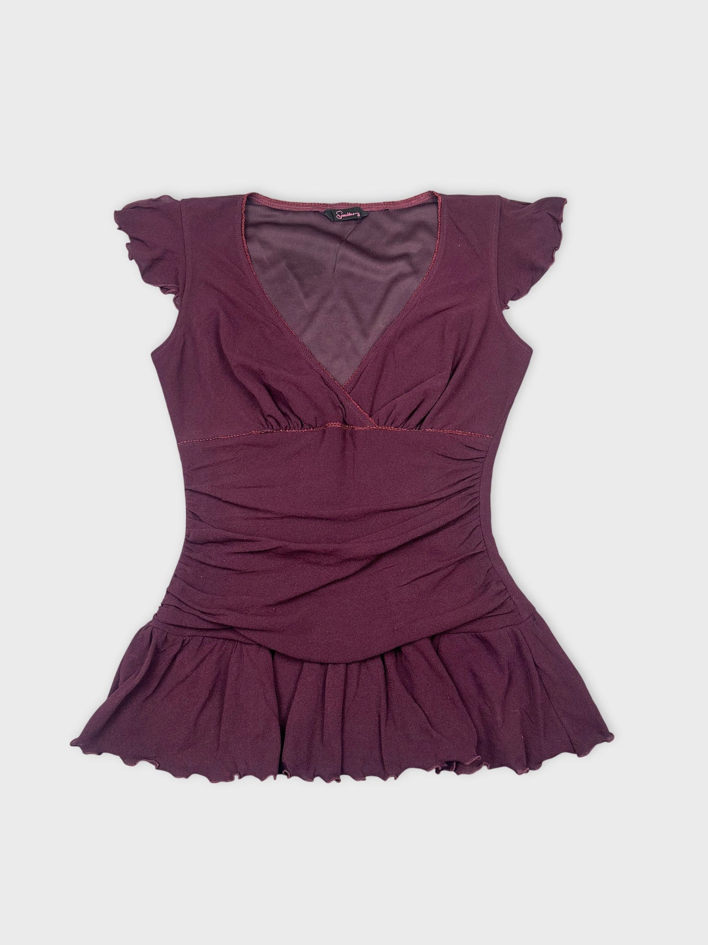 Front view of a burgundy top with ruffled sleeves and flared hem.