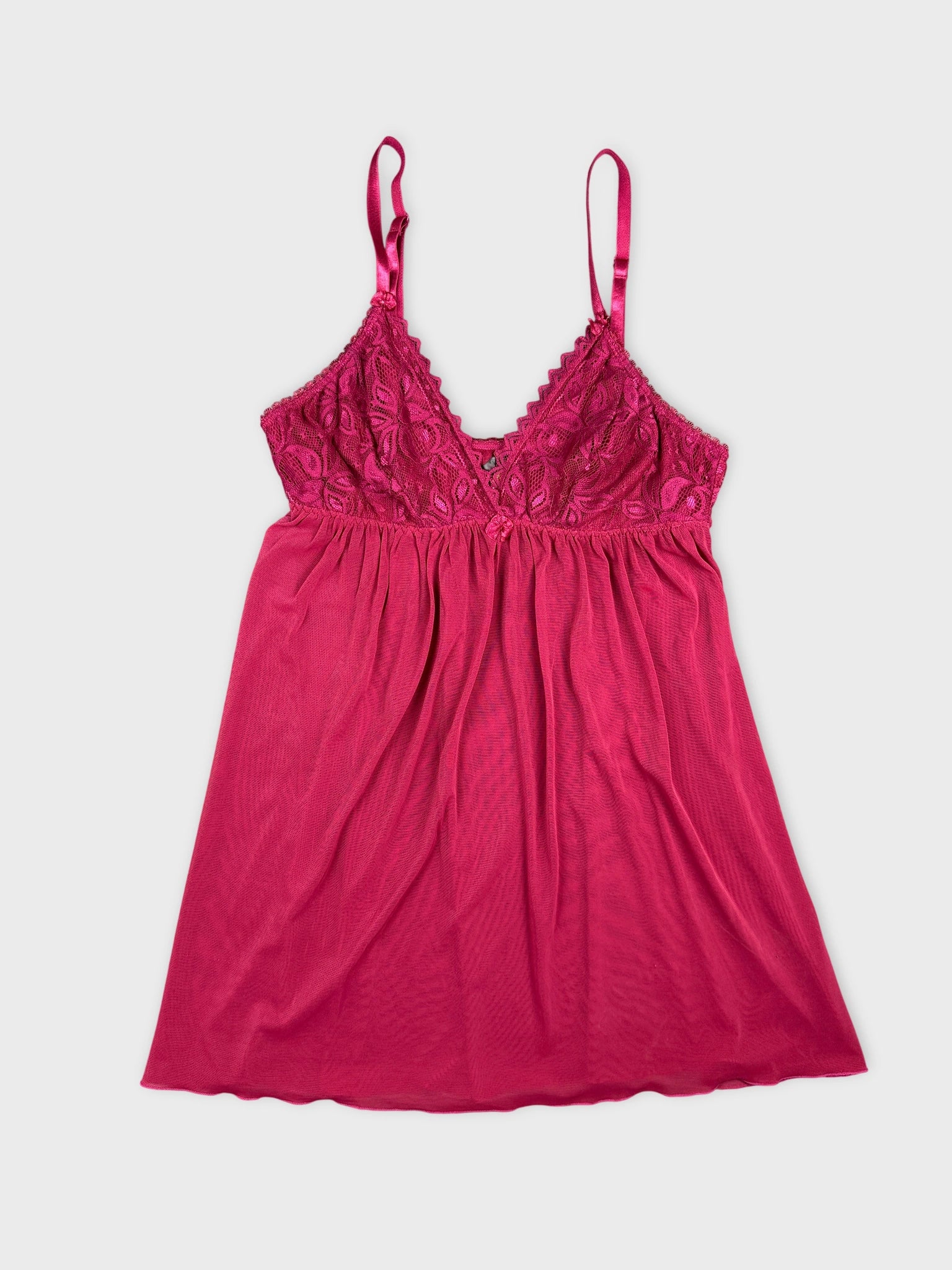 Front view of a pink lace-trimmed camisole top with adjustable straps.